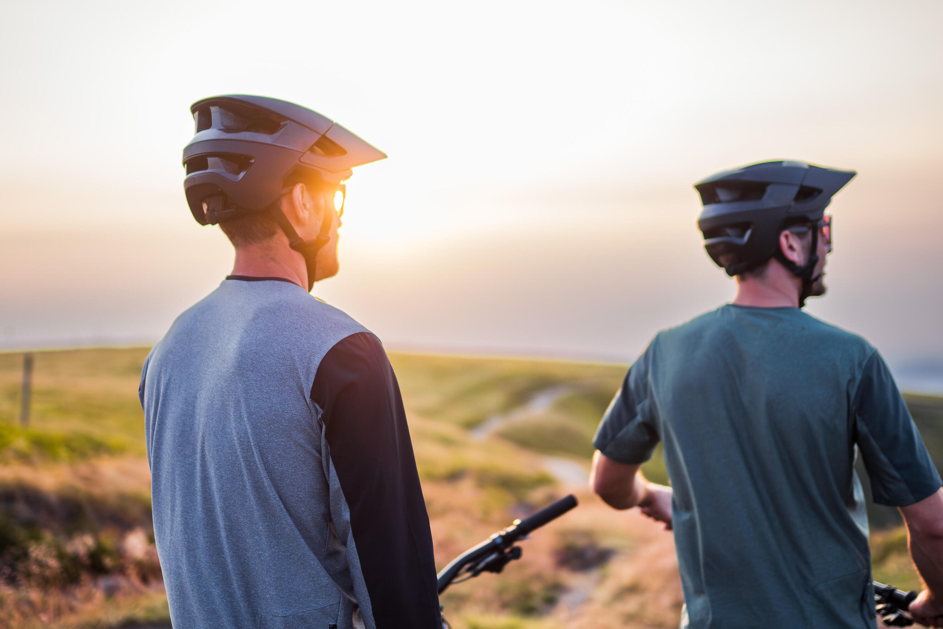 Zwei Männer die einen Helm tragen und in die Ferne schauen.