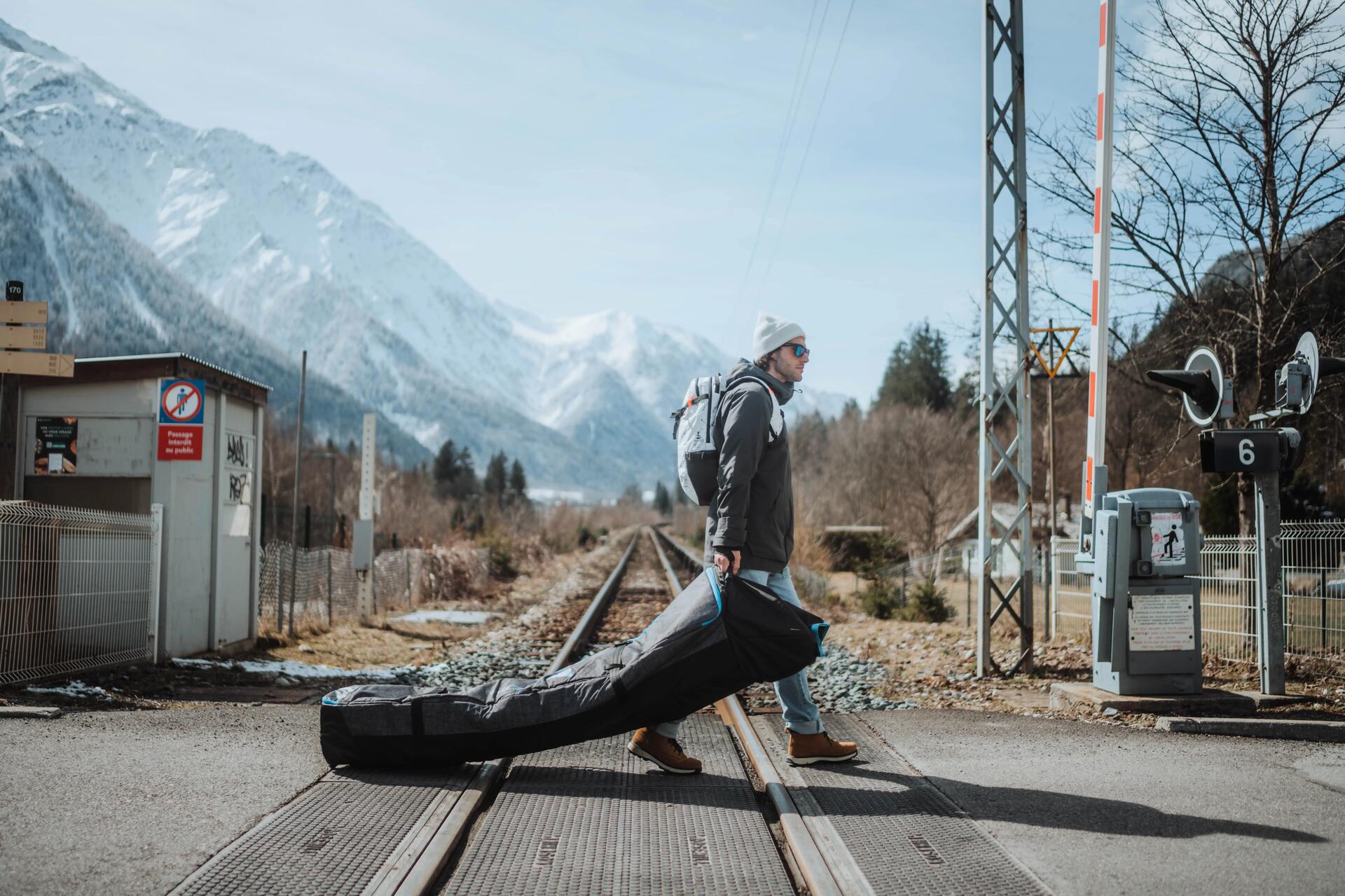 Mężczyzna idący z pokrowcem snowboardowym