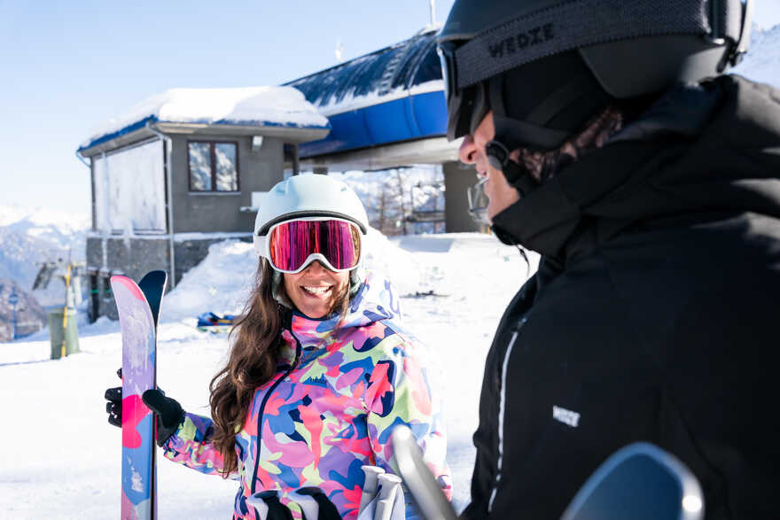 Muškarac i žena na skijaškoj stazi opremljeni skijaškom opremom.