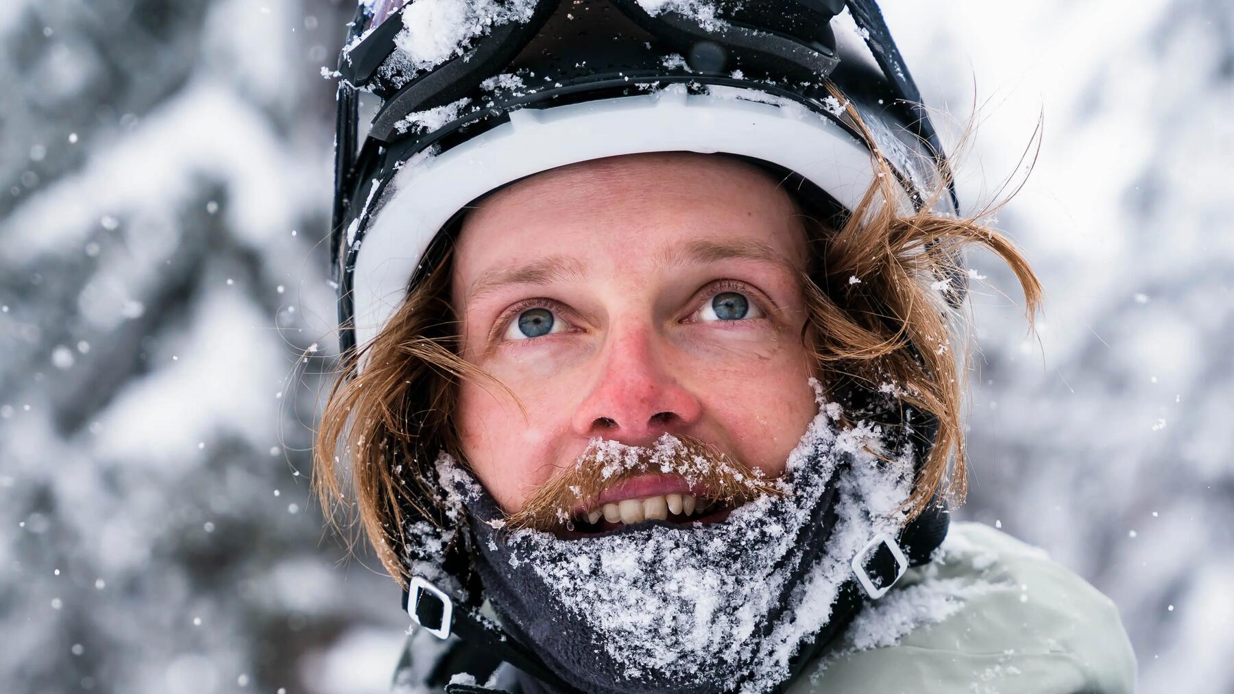 Mann mit Skihelm und Sturmmaske schaut nach oben.
