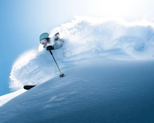 Mężczyzna uprawiające freeskiing wykonujący akrobacje podczas jazdy na nartach z góry