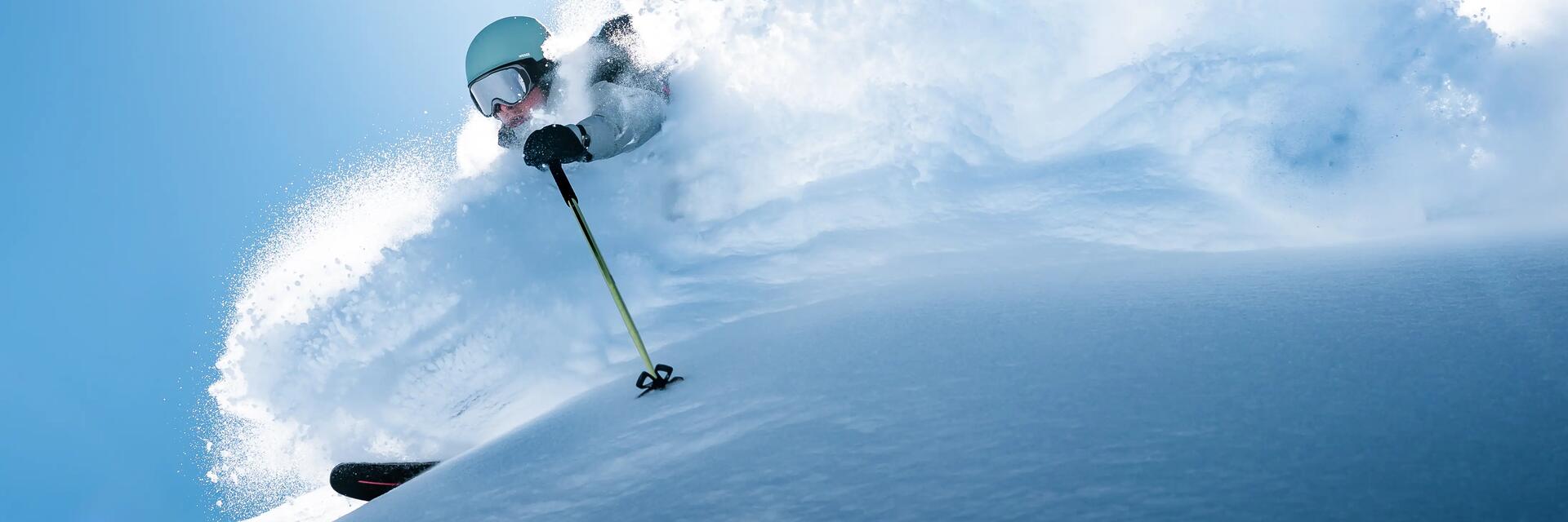 Mężczyzna uprawiające freeskiing wykonujący akrobacje podczas jazdy na nartach z góry