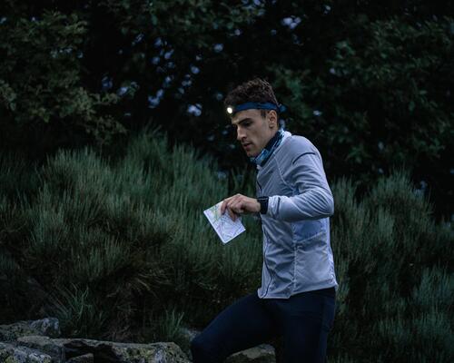 Mann joggt im Wald mit Stirnlampe