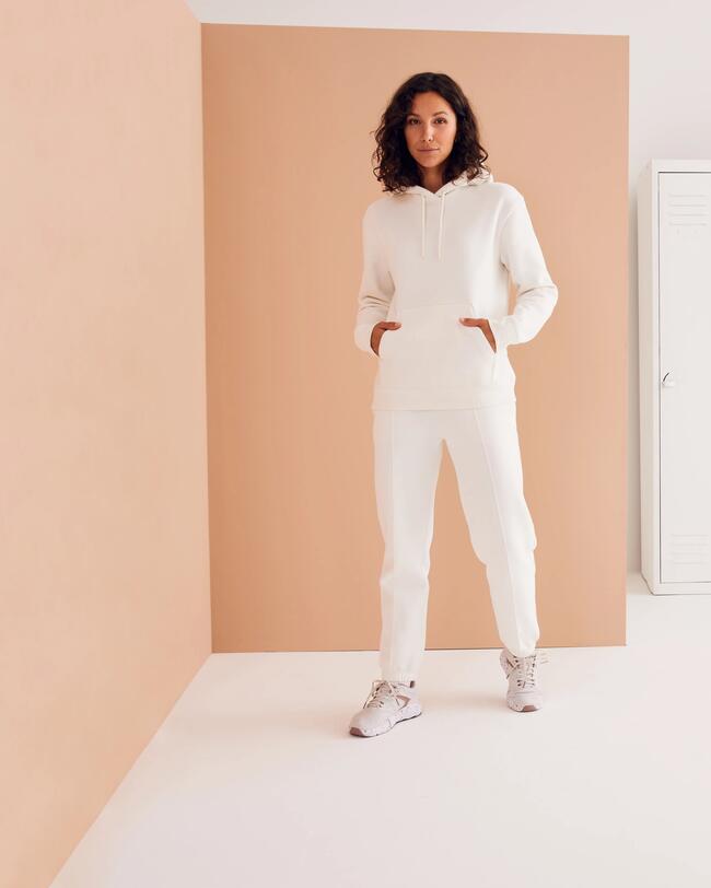 Eine Frau trägt eine weiße Jogginghose.