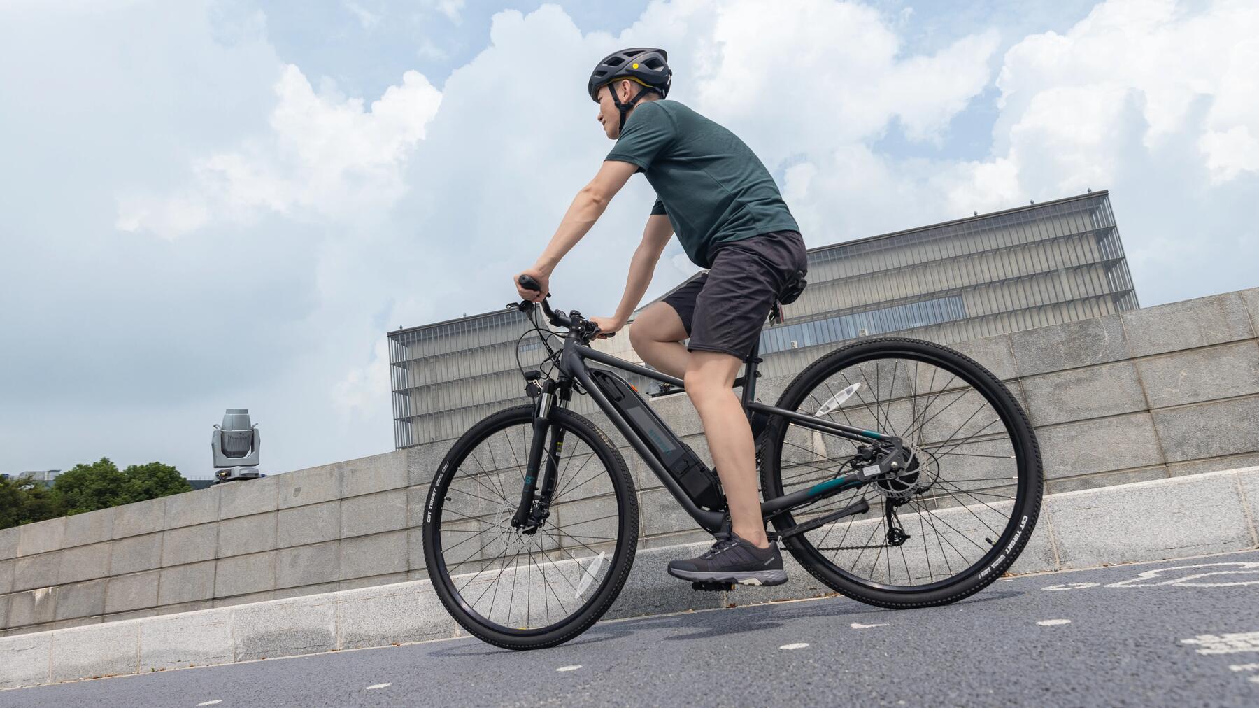 Mężczyzna w kasku rowerowym jadący na rowerze elektrycznym