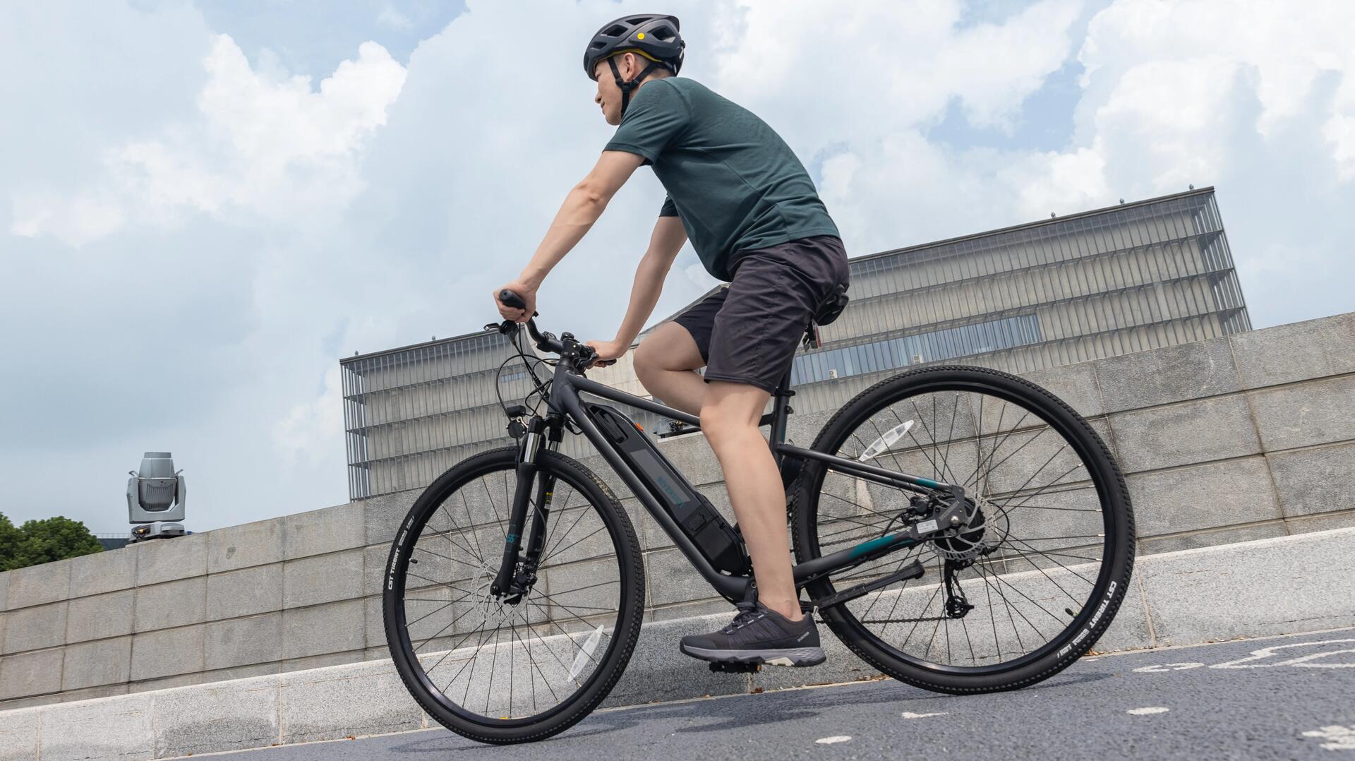 homem a pedalar na cidade com uma bicicleta elétrica