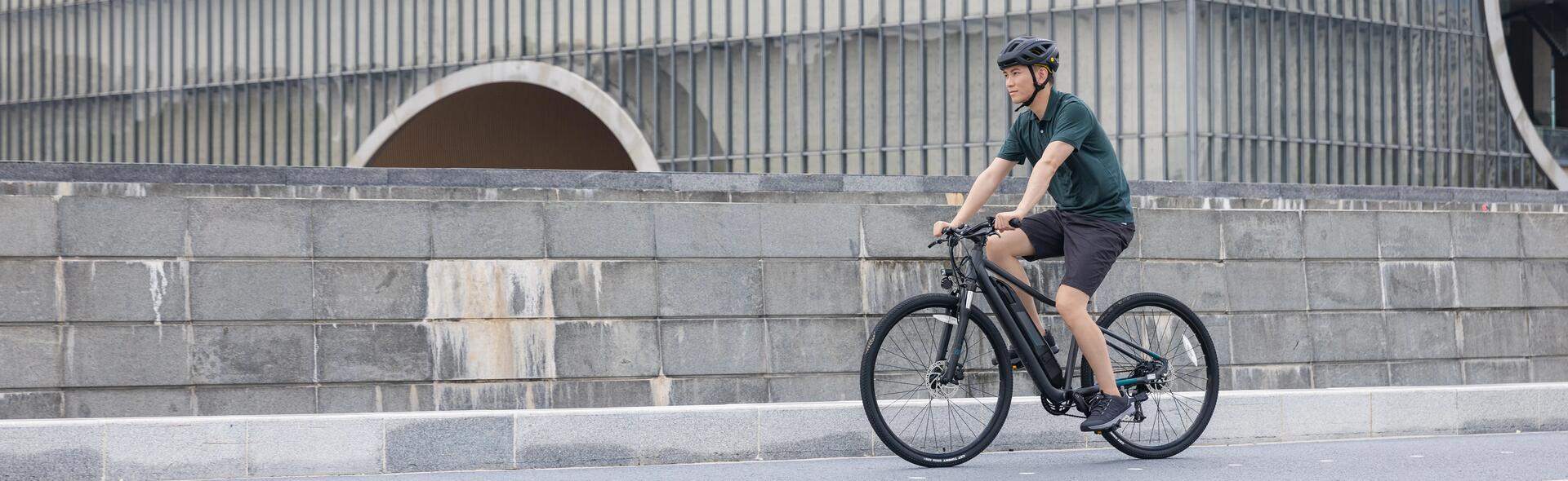 mężczyzna w kasku rowerowym jadący na rowerze elektrycznym z akumulatorem  