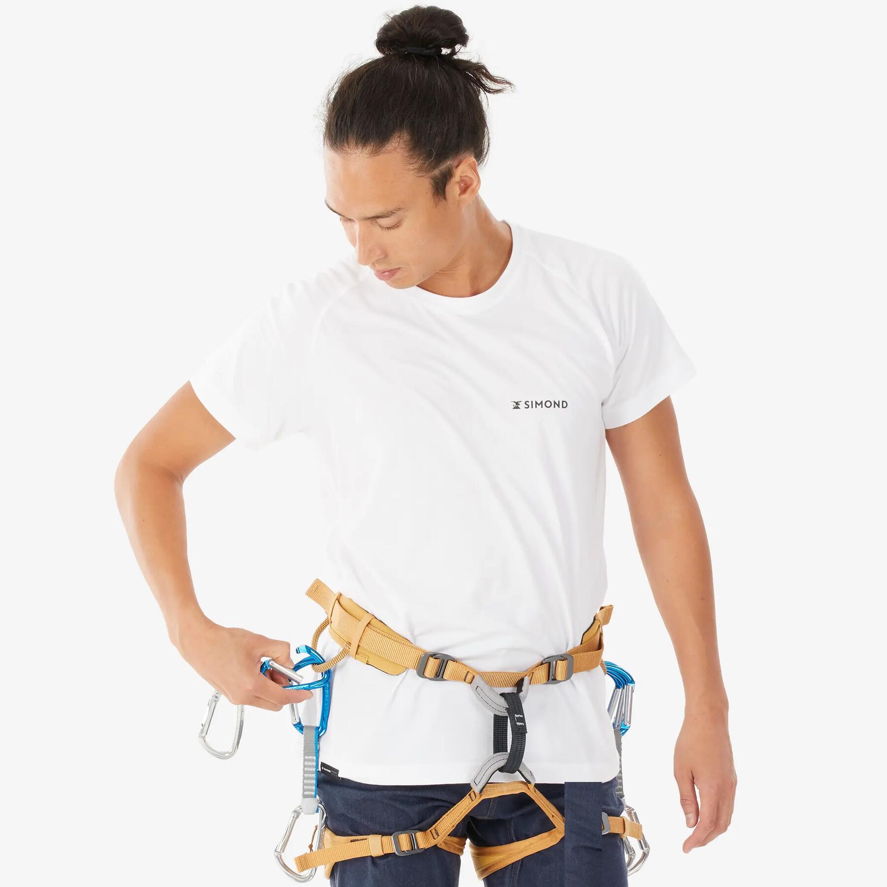Man in a white t-shirt wearing a climbing harness