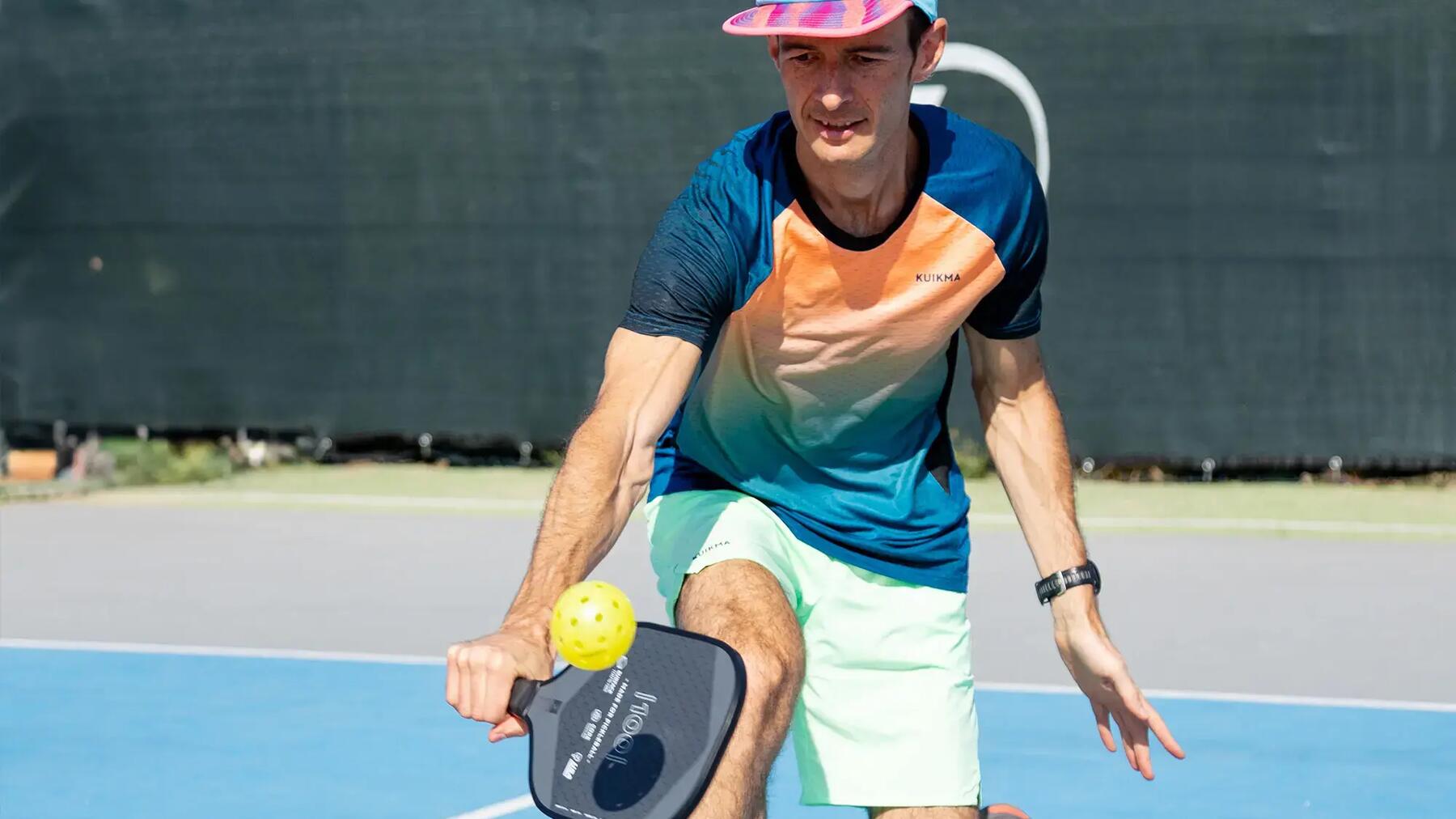Mężczyzna grajacy w pickleballa na korcie