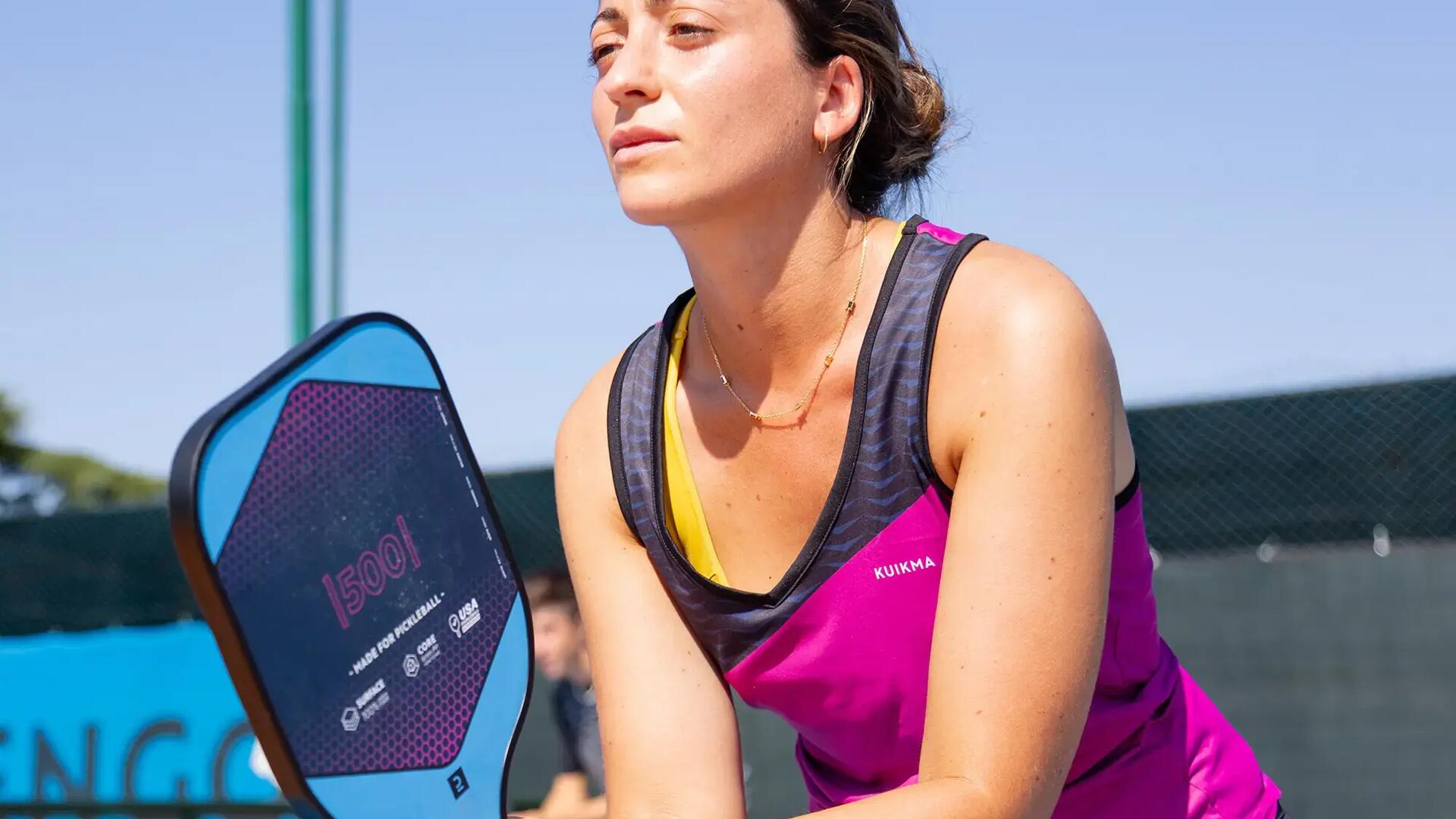Vrouw die klaar staat om een service te ontvangen tijdens een potje pickleball.