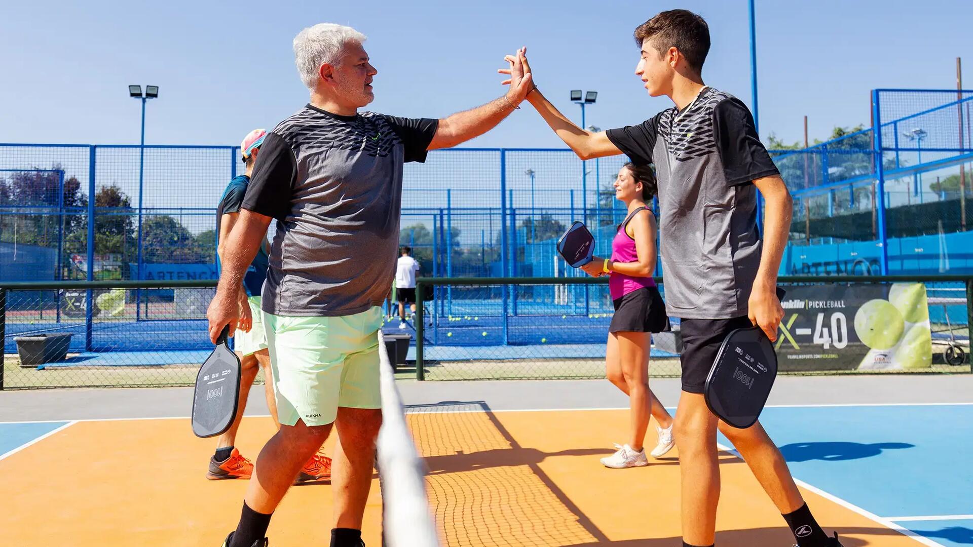 Spelers zijn klaar met een pickleball wedstrijd en geven elkaar een hand na afloop.