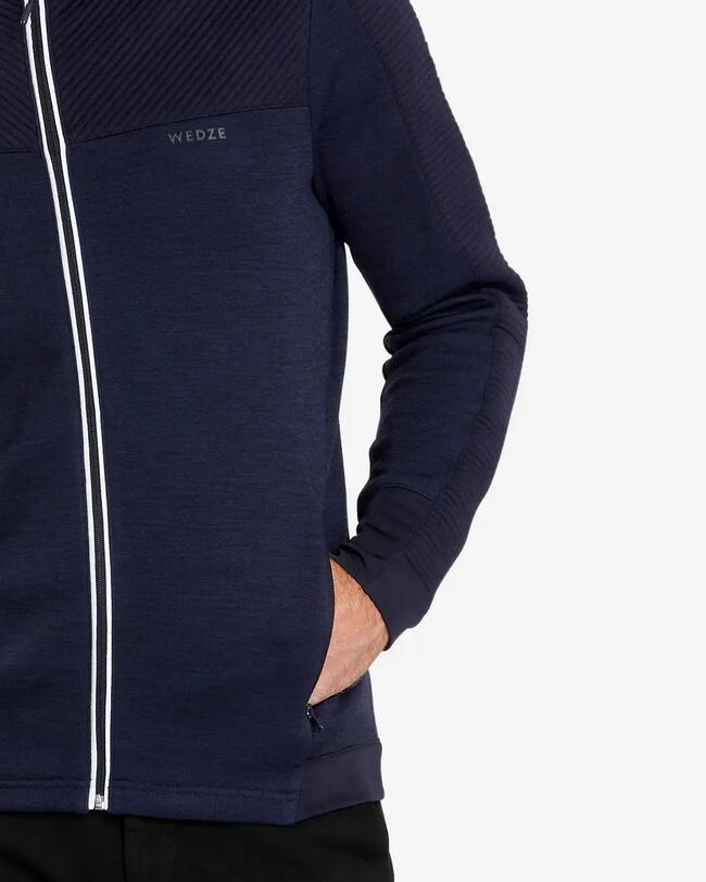Nahaufnahme der Seitentasche der marineblauen Unterziehjacke, in der der Mann seine Hand tut.