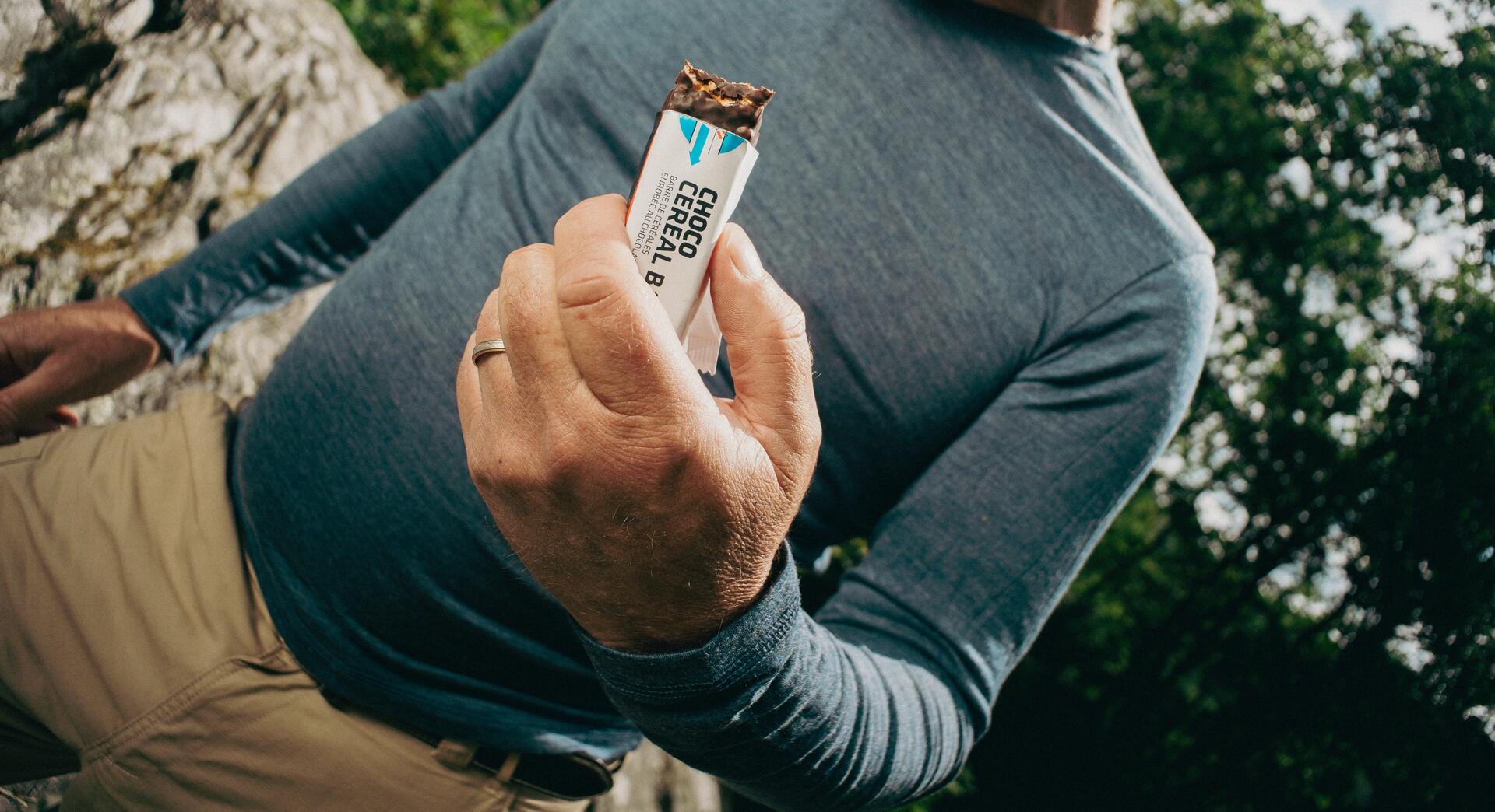 woman eating a granola bar while hiking
