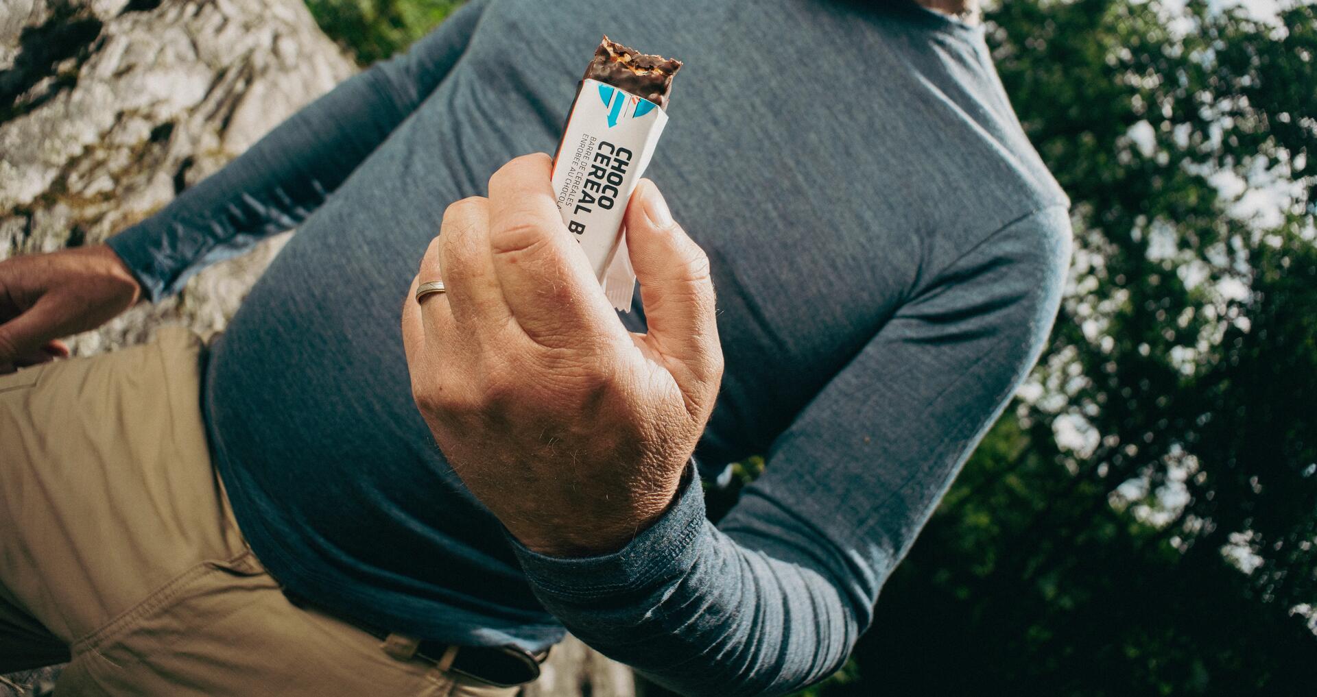femme qui mange une barre tendre en randonnée