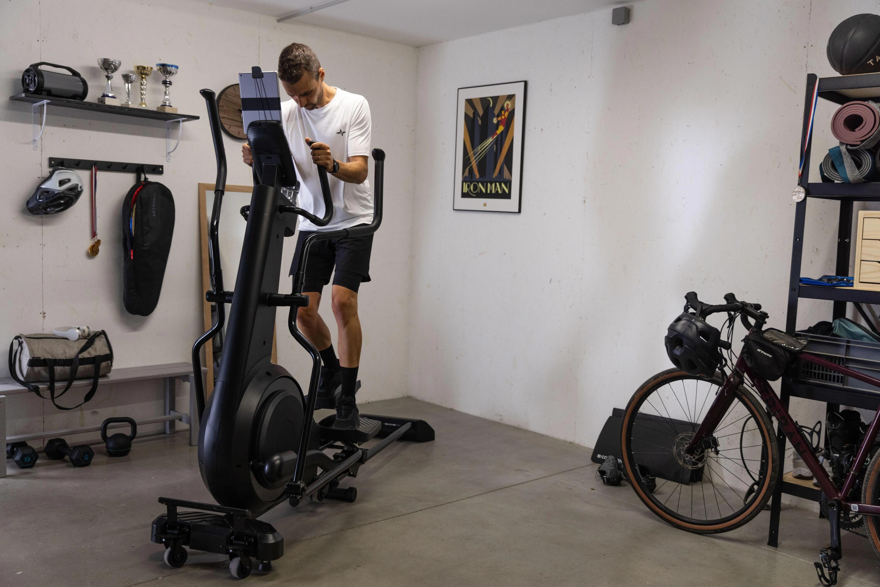 Ein Mann trainiert auf einem Ellipsentrainer in einem Heimfitnessraum.