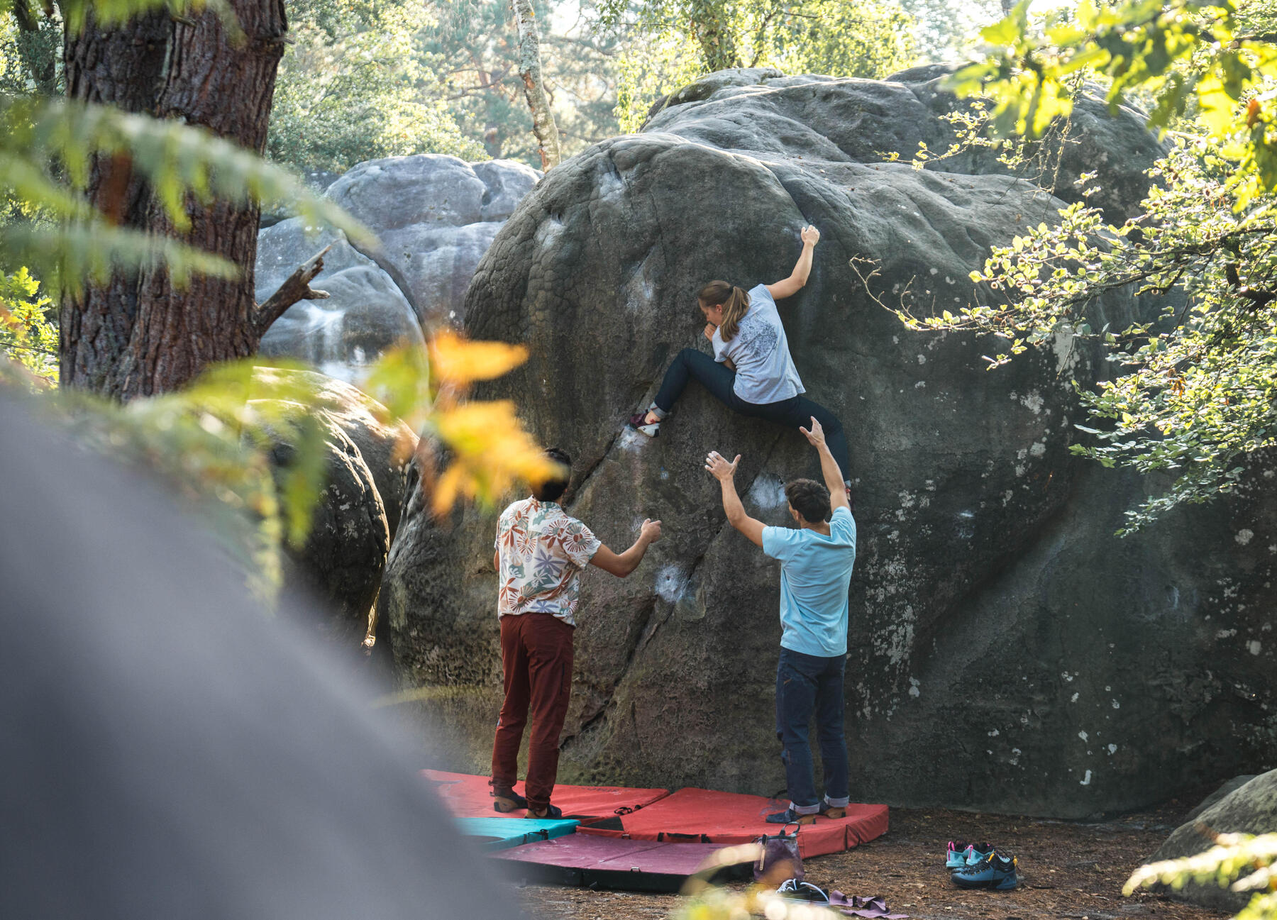 Drei Freunde Bouldern mit passender Ausrüstung und sichern sich gegenseitig