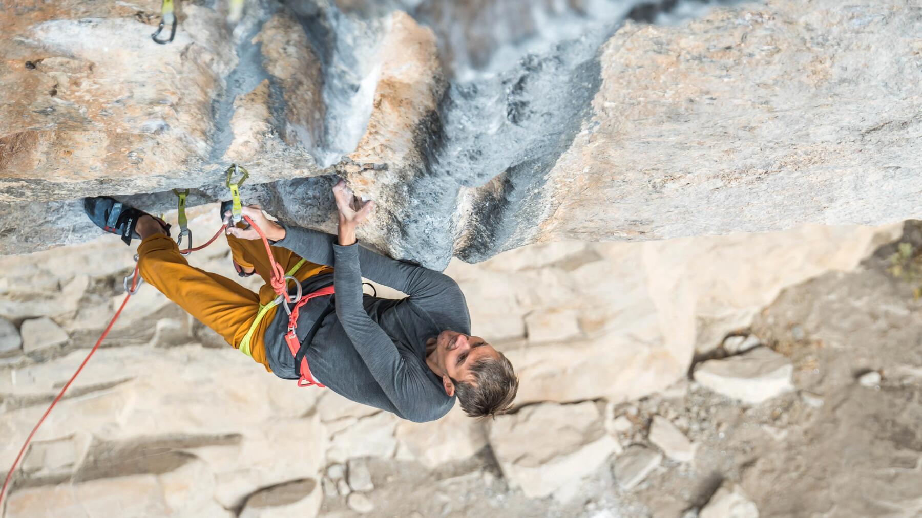 Mann klettert am Fels in der Eifel