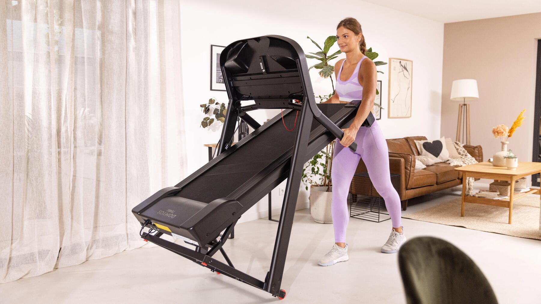 Kobieta w odzieży fitness składająca bieżnię domową