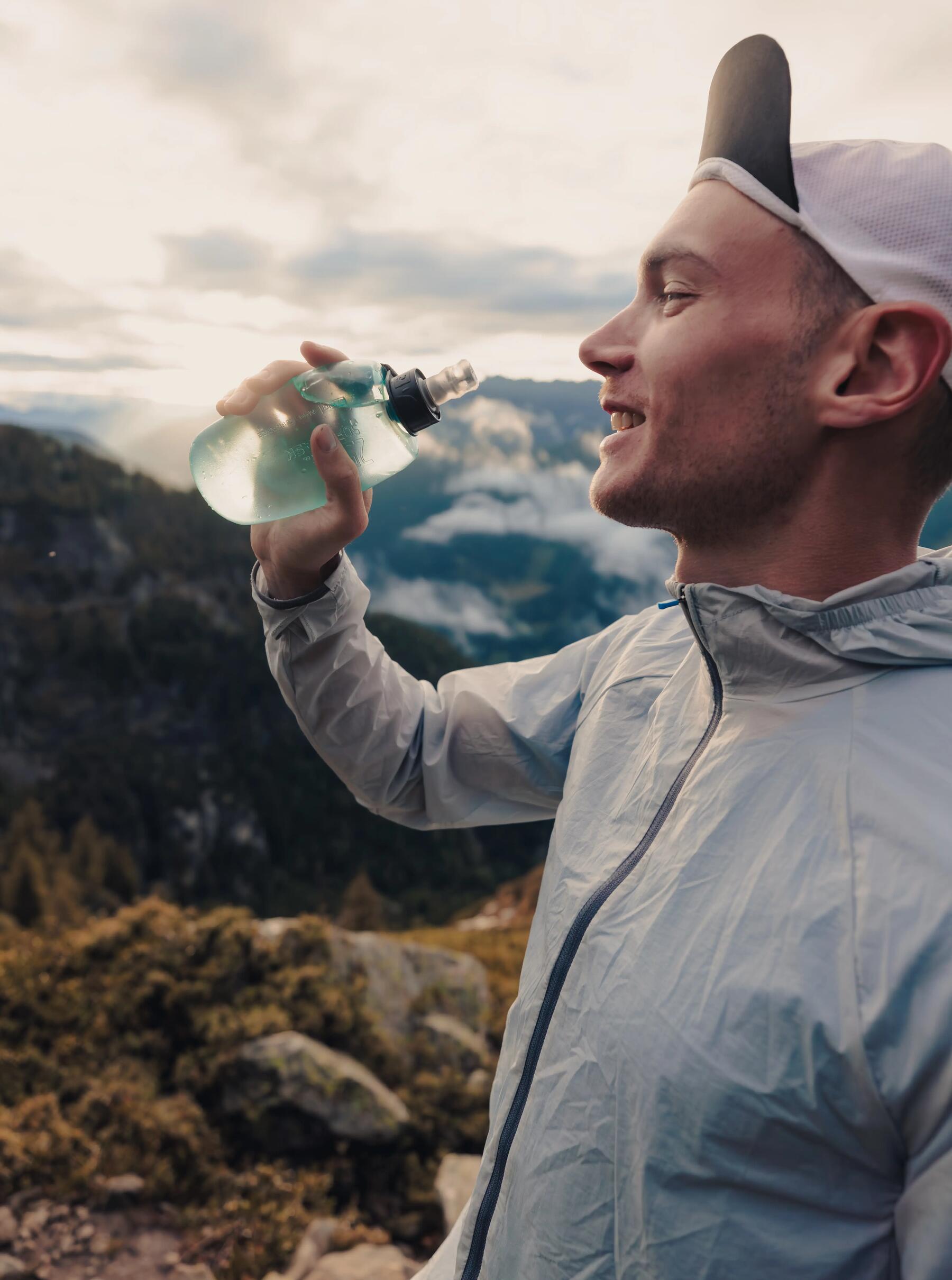 Mężczyzna pijący wodę bogatą w składniki mineralne polecaną przy osteoporozie podczas aktywności fizycznej