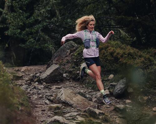 Kobieta biegnąca po górach biorąca udział w koronie polskich maratonów