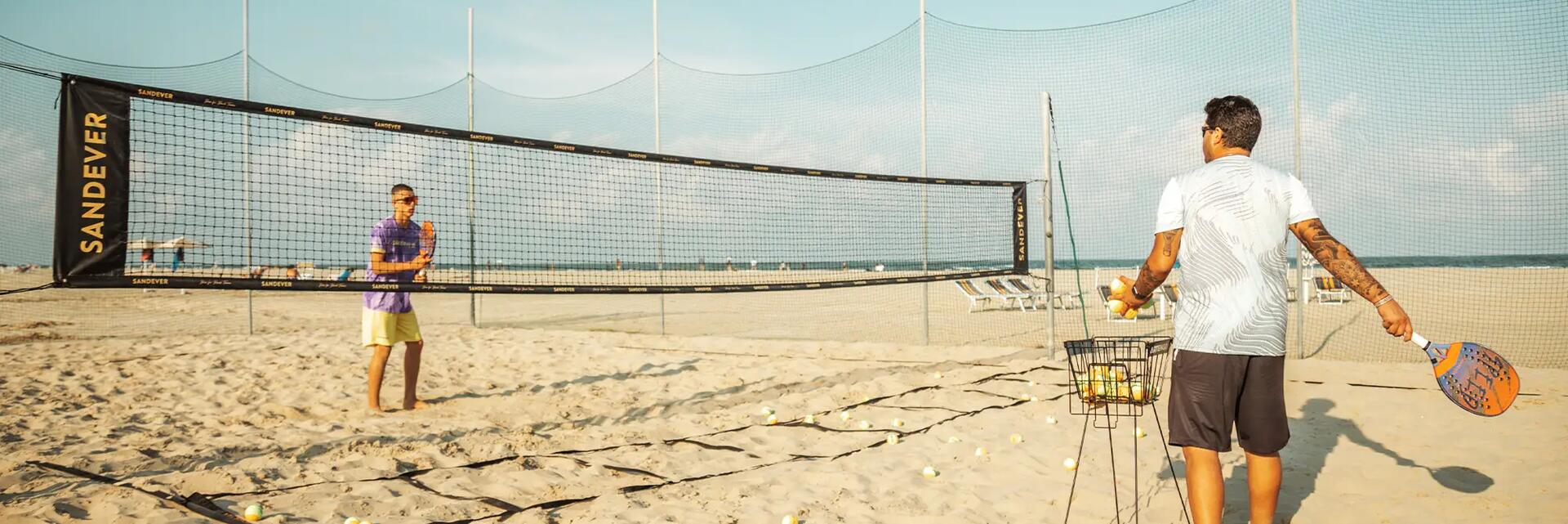 Mężczyźni grający w tenisa plażowego na plaży