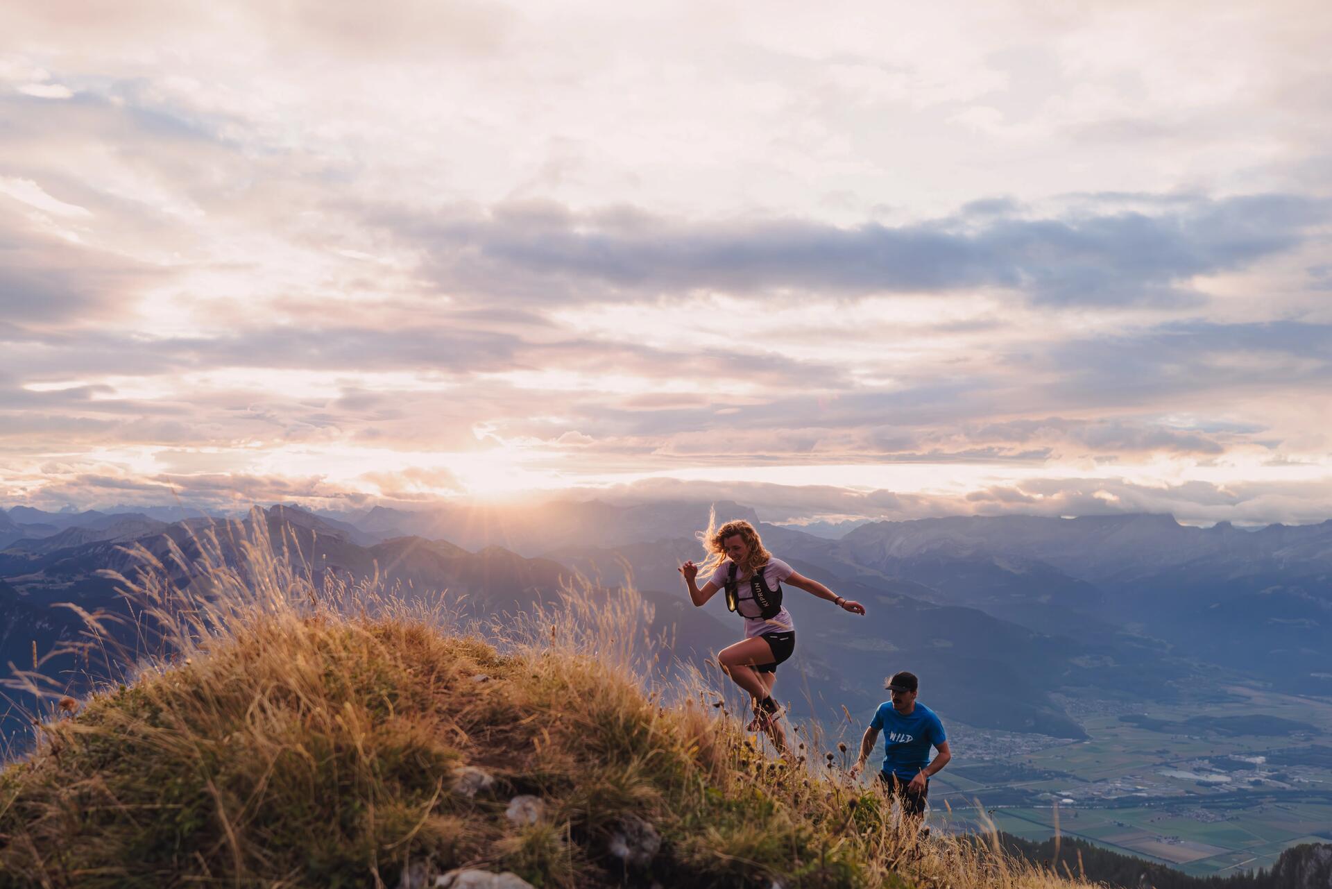 man and woman running by a scenic lake