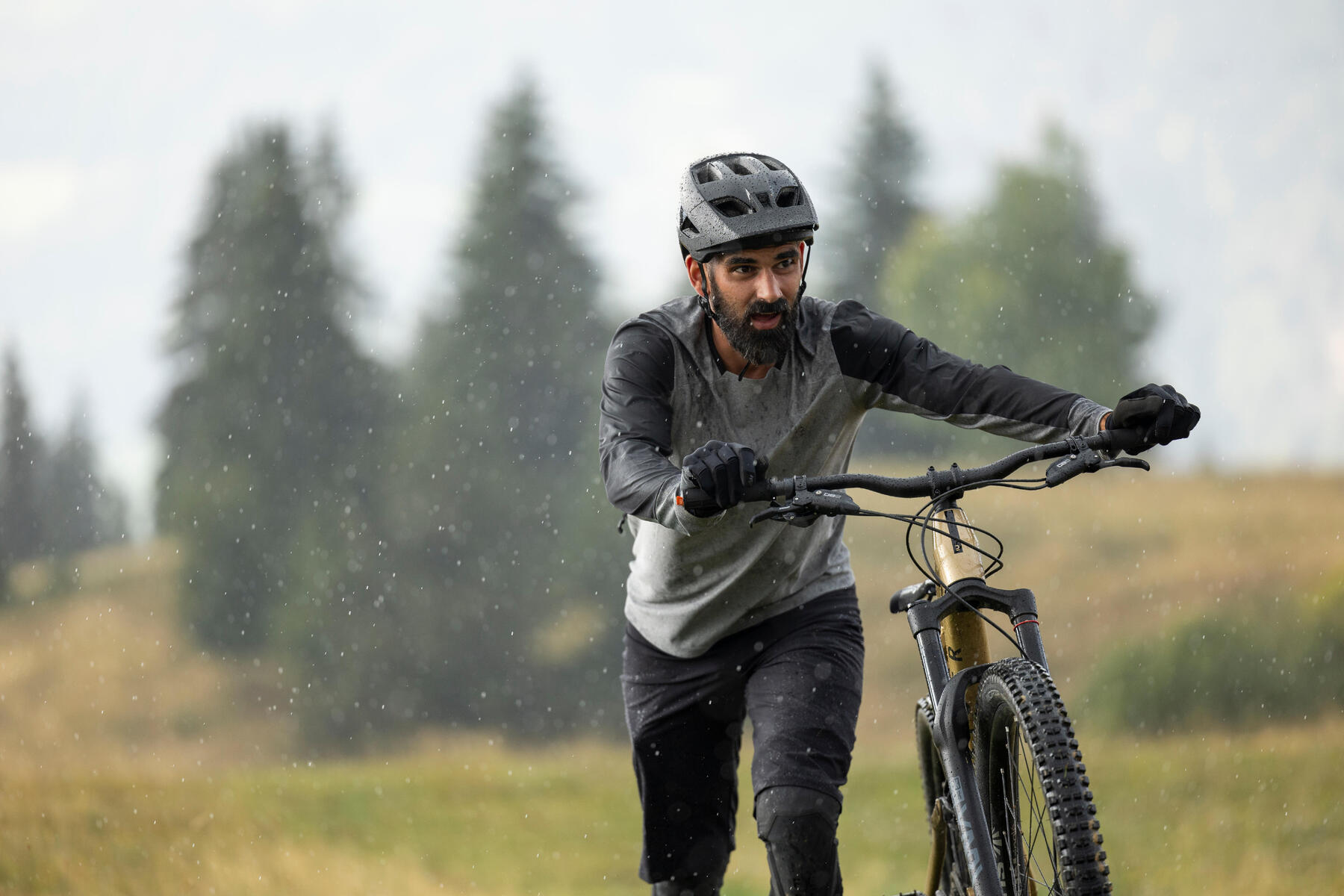 Mężczyzna idący z rowerem MTB
