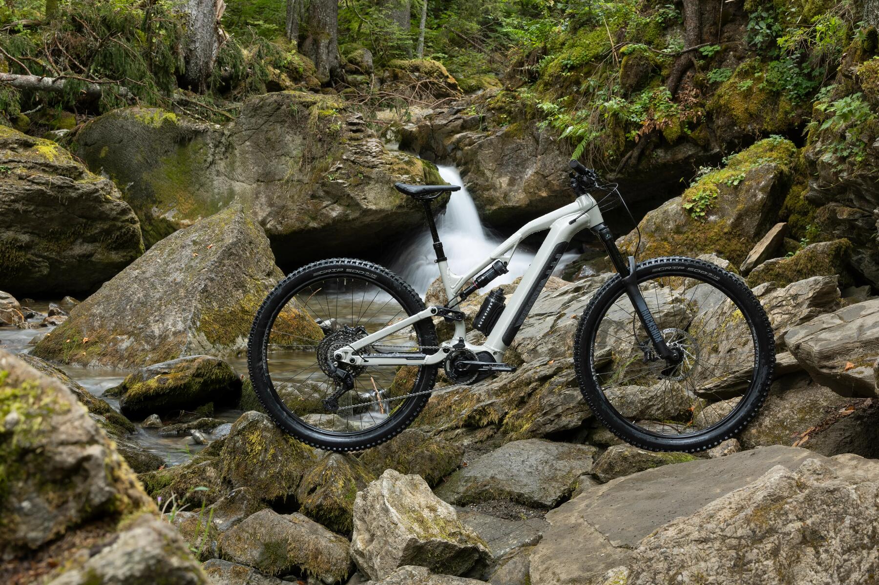 Rower elektryczny mtb stojący na kamieniach przy wodospadzie