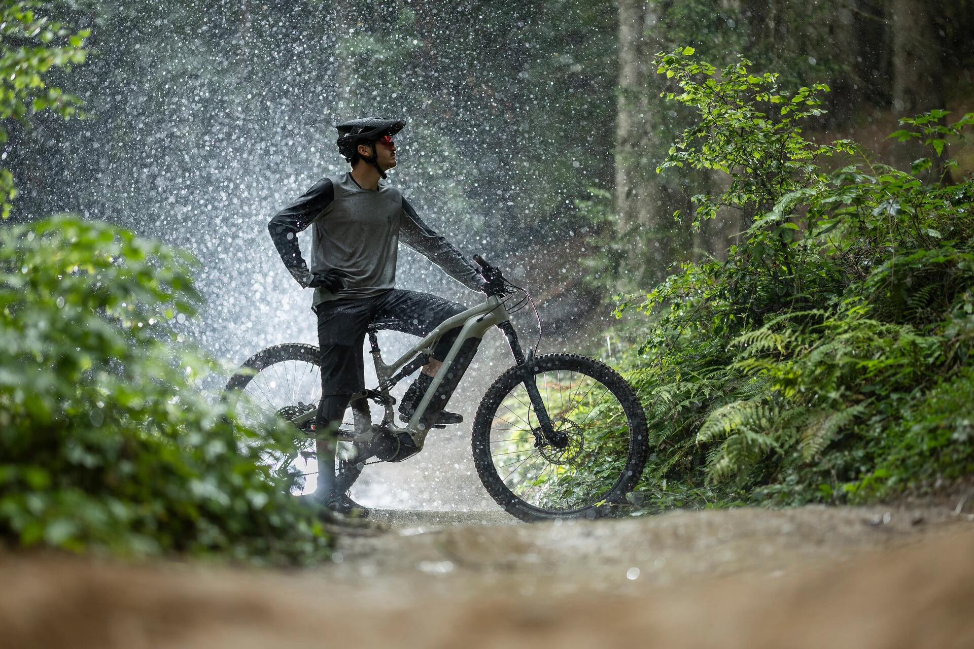mężczyzna w kasku i odzieży sportowej siedzący na rowerze elektrycznym w lesie