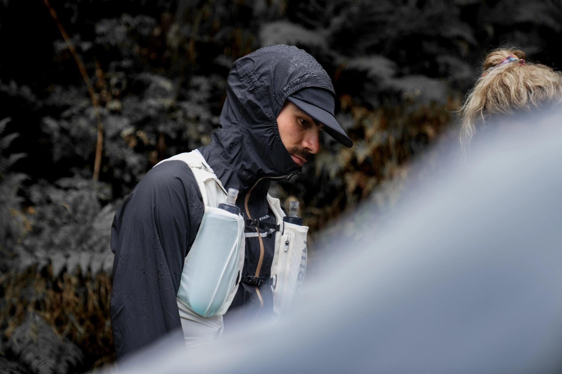 A man on a bicycle is about to drink from the tube of his water bag