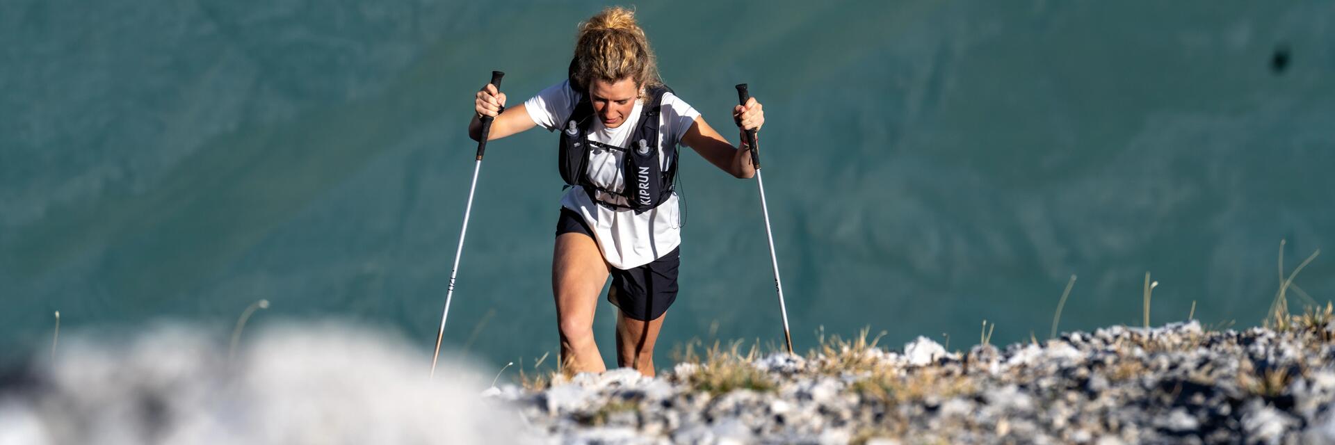 traileuse en montagne avec des batons de trail