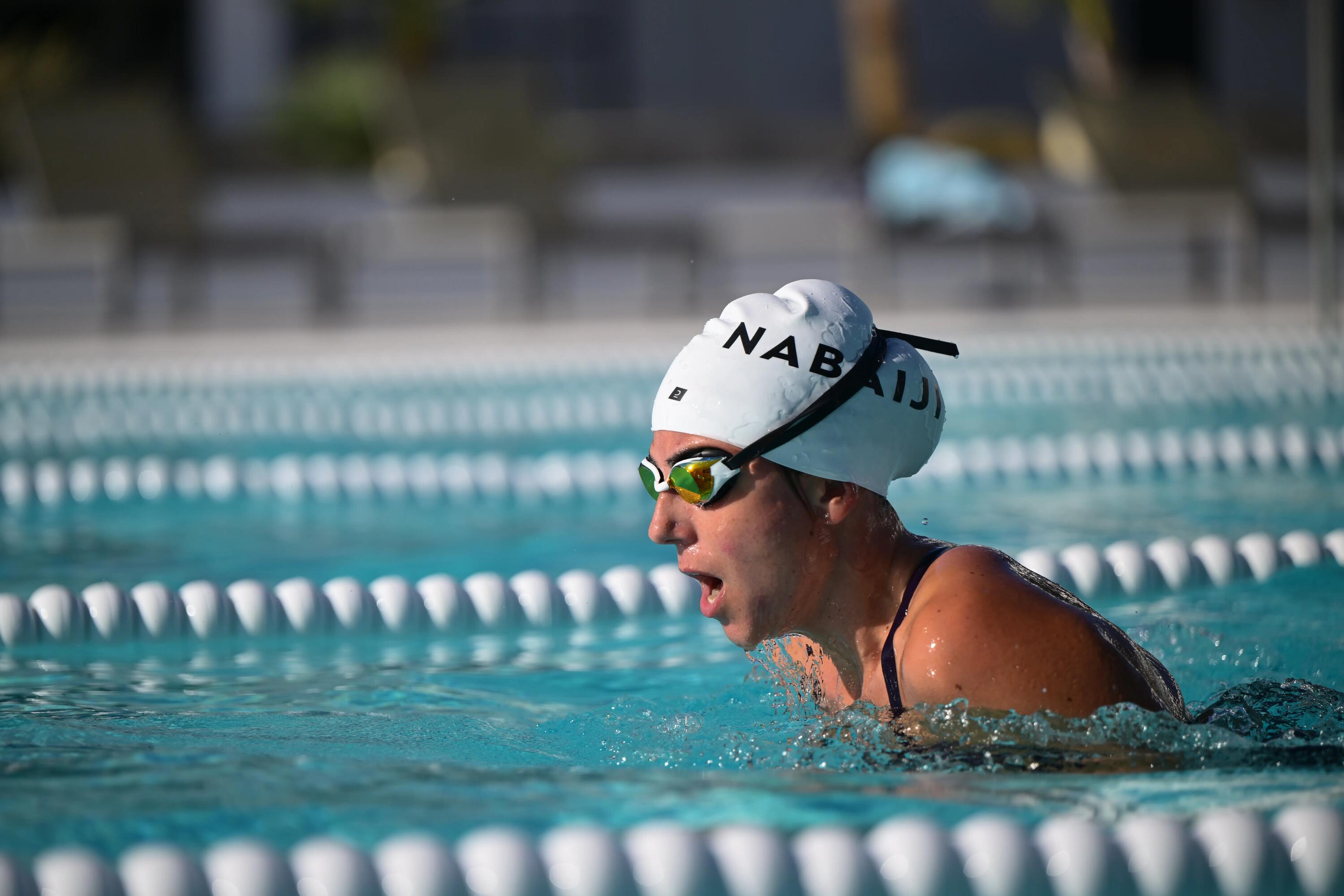 Frau trägt beim Schwimmen eine Badekappe