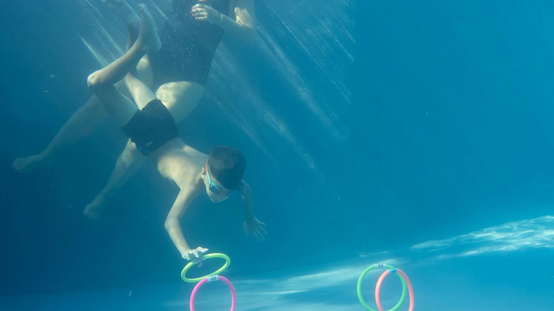 a kid jumps in water on daddy's arms