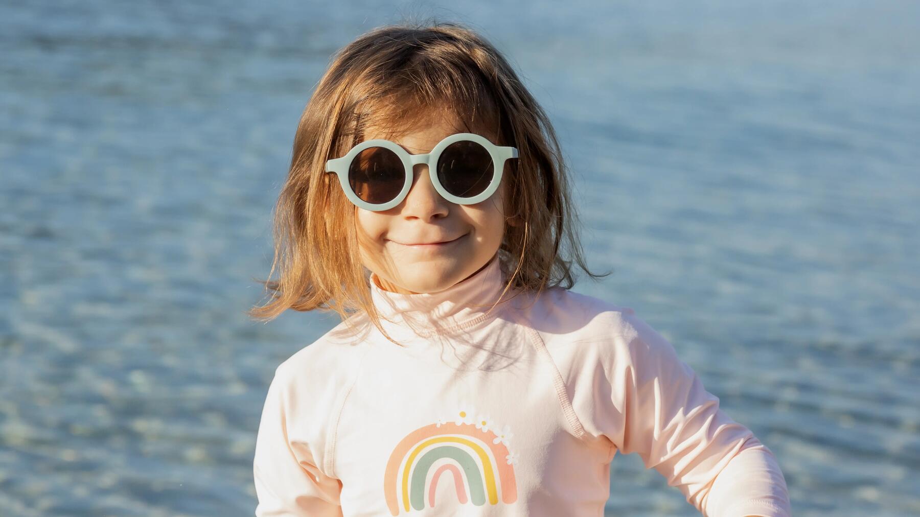 Ein Mädchen trägt ein UV-Shirt für Kinder am Strand