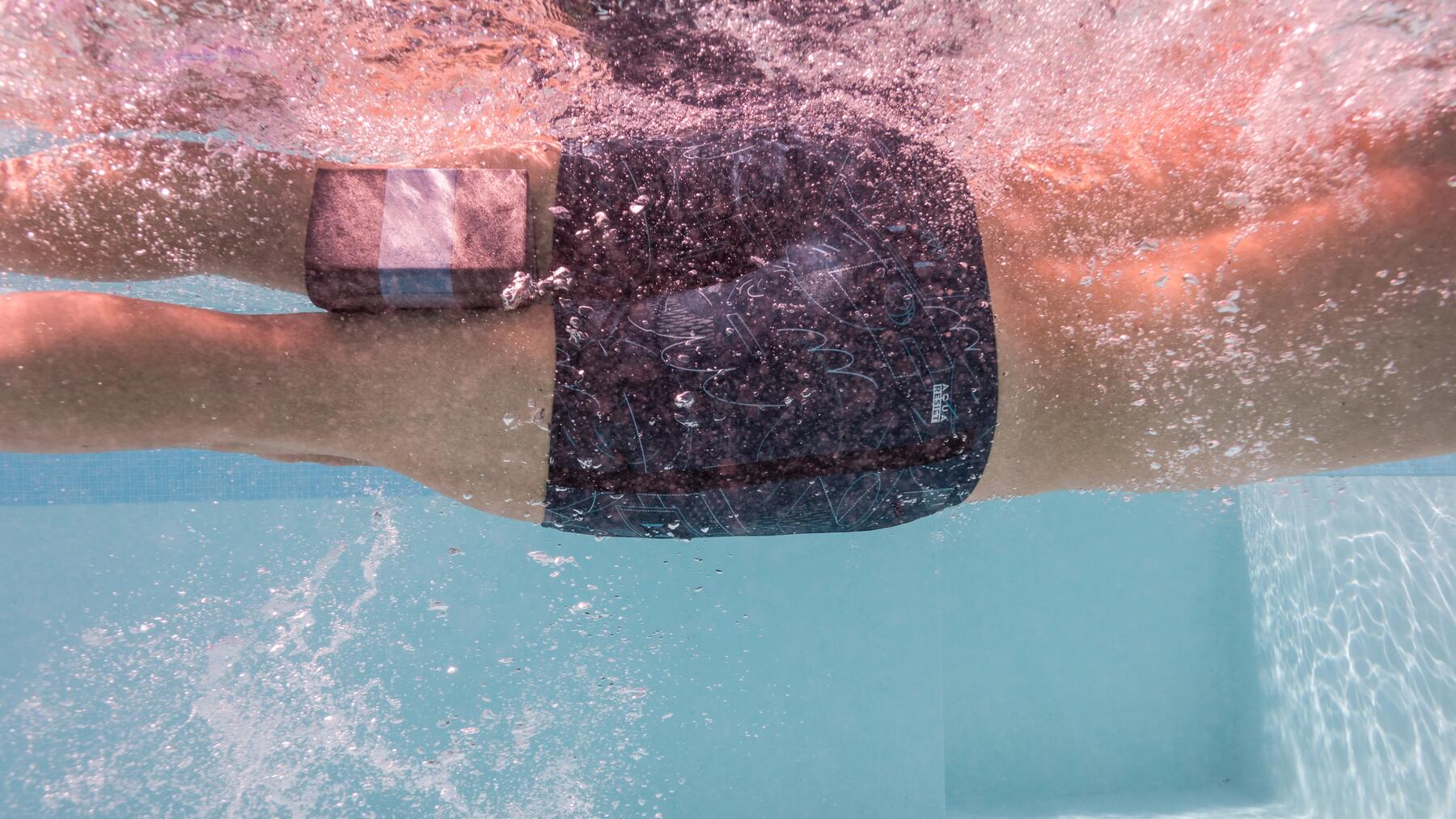 Mann schwimmt mit Pull Buoy im Becken