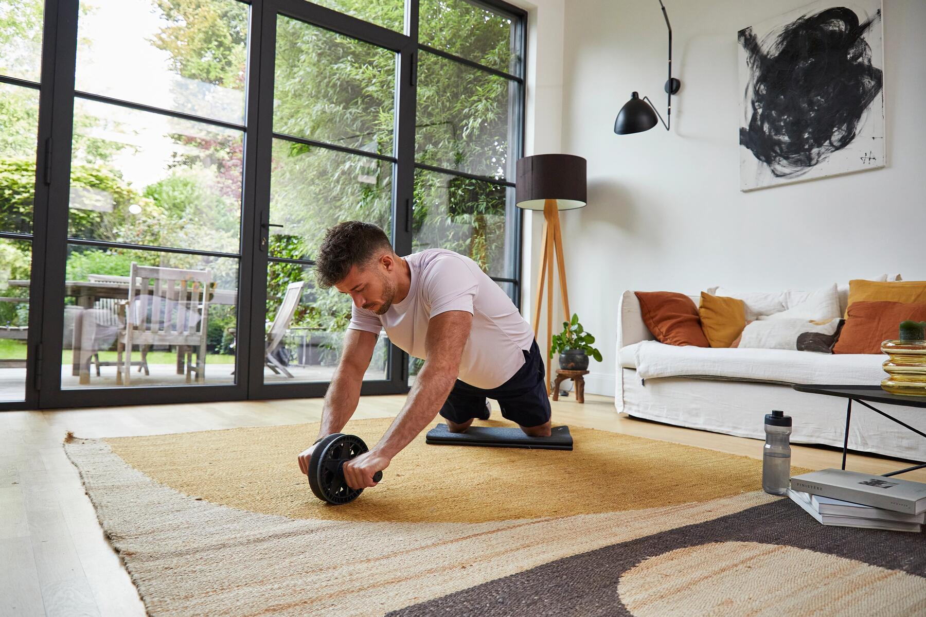 a man using an ab wheel in a gym