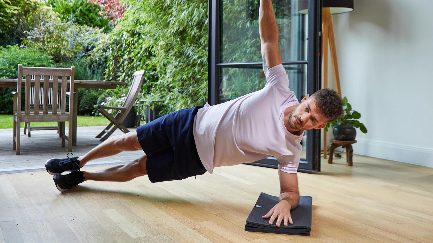 Mężczyzna wykonujący side plank podczas treningu pilates dla mężczyzn