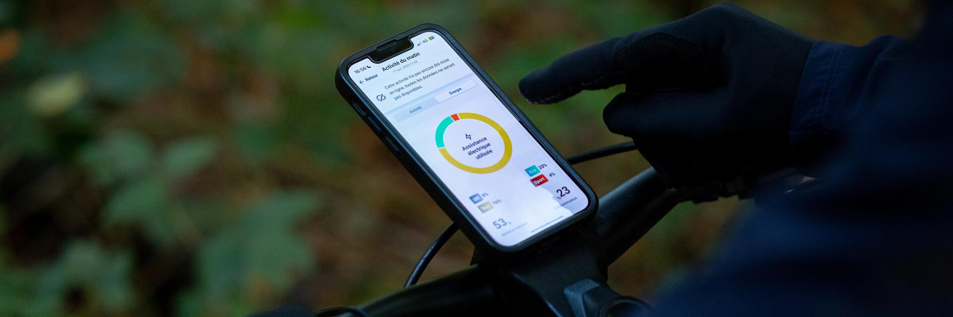 Rowerzysta korzystający z telefonu przymocowanego do kierownicy za pomocą uchwytu na telefon do roweru