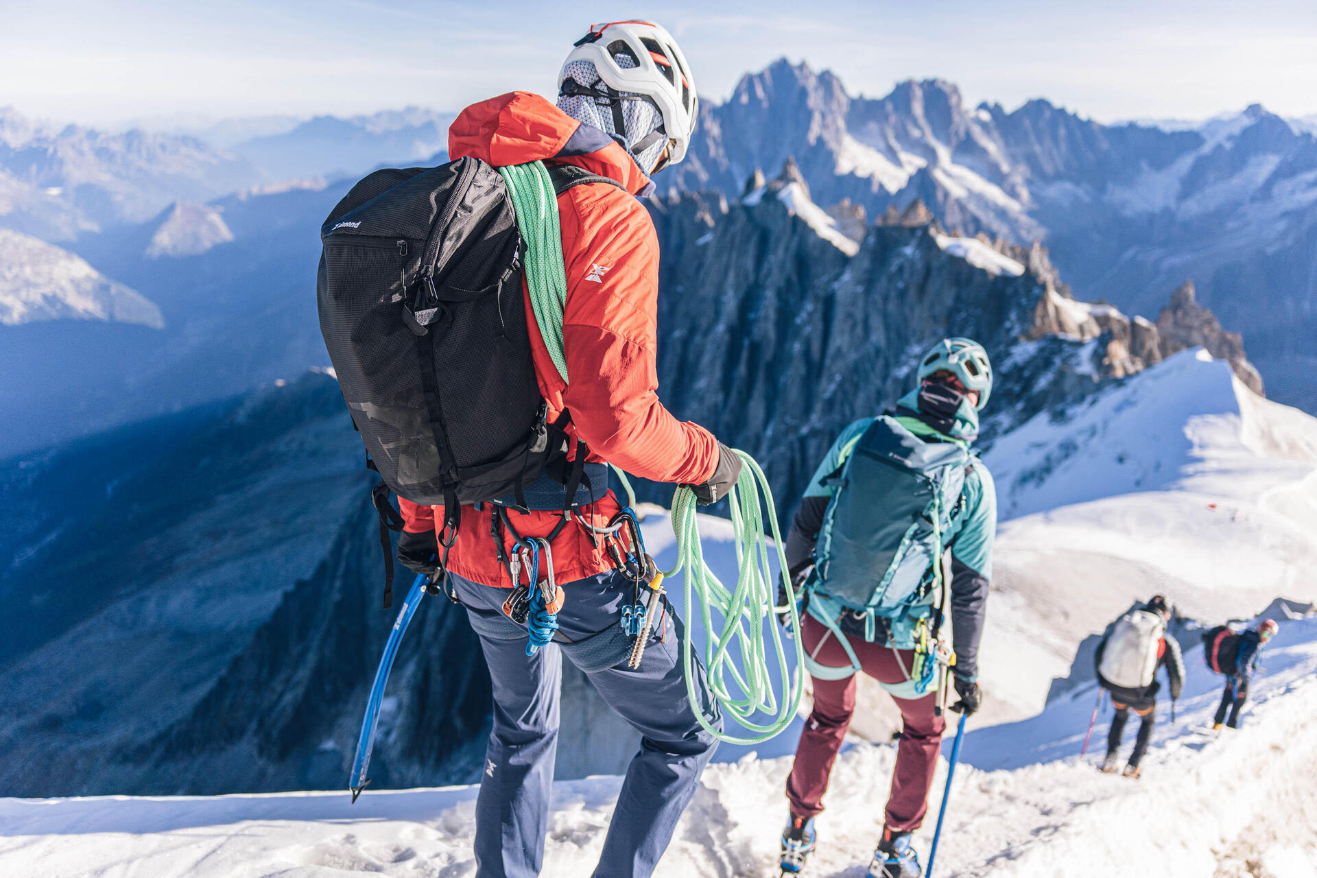 Himalaiści ze sprzętem alpinistycznym poruszający się po górach uprawiając himalaizm zimowy