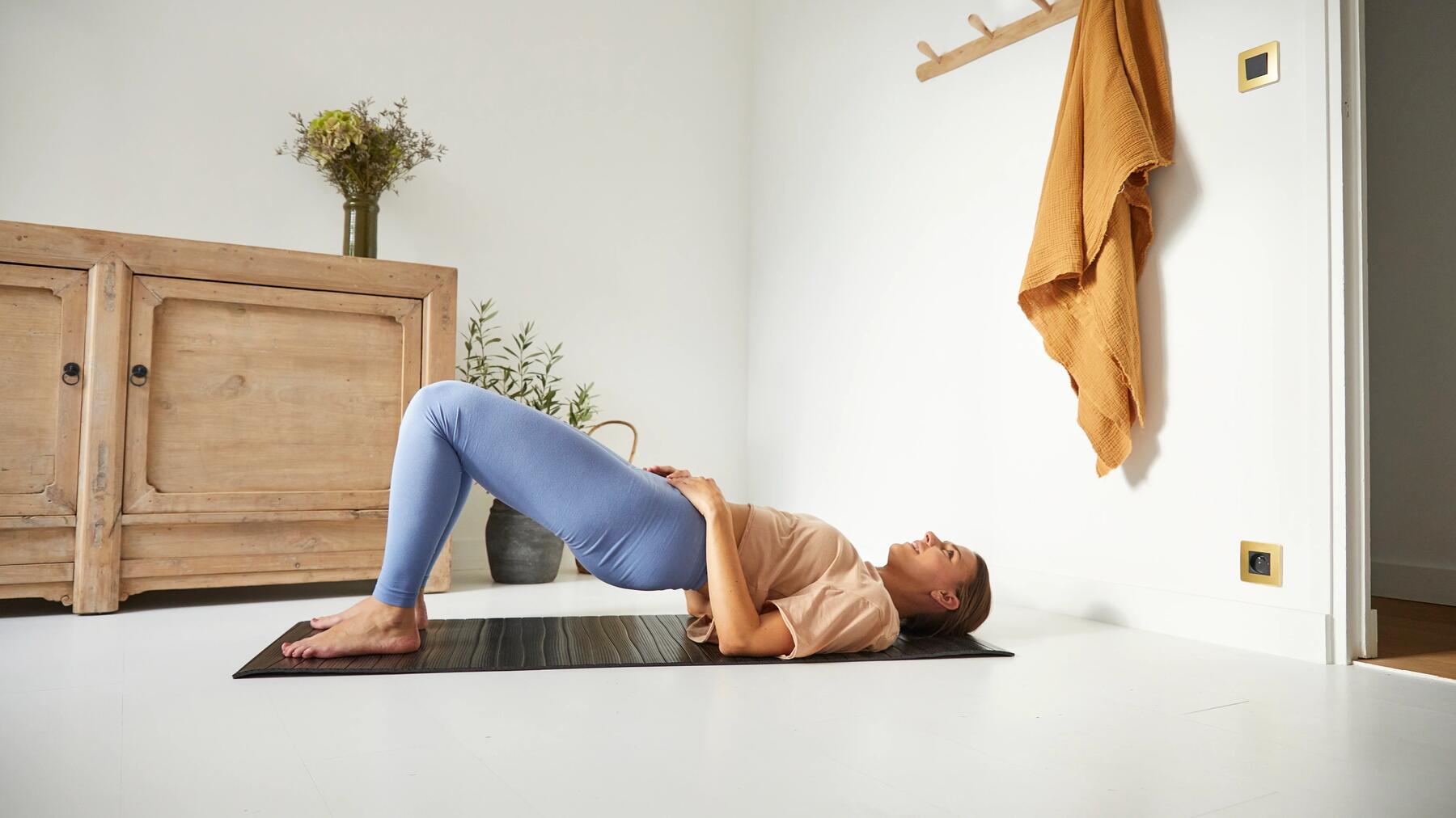 Frau absolviert Beintraining Zuhause auf einer Yogamatte