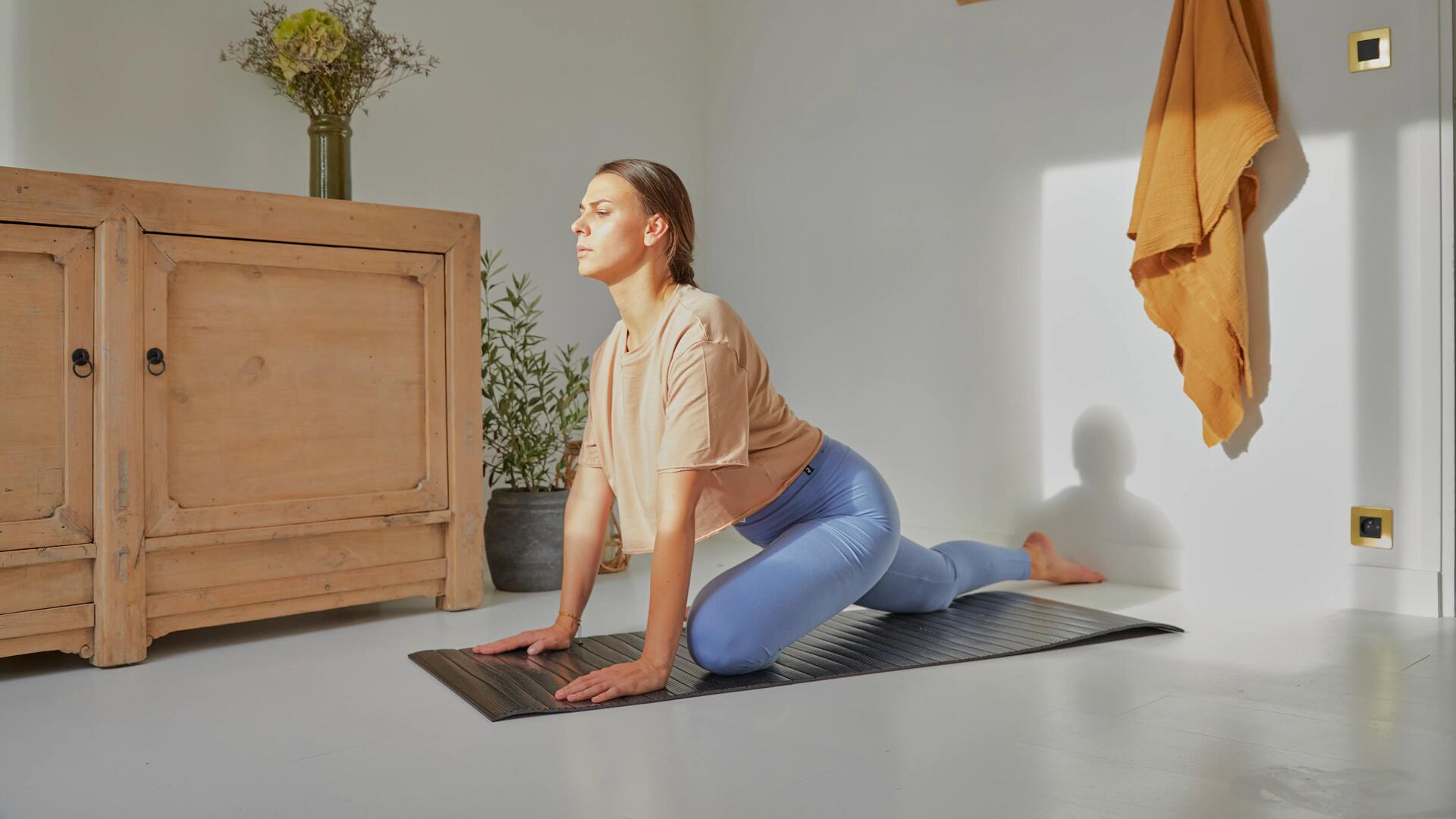 Kobieta w odzieży sportowej trenująca pilates na macie