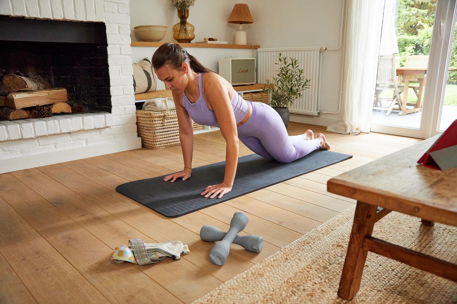 Eine Frau beim zügigen beim Home Workout auf einer Yogamatte.