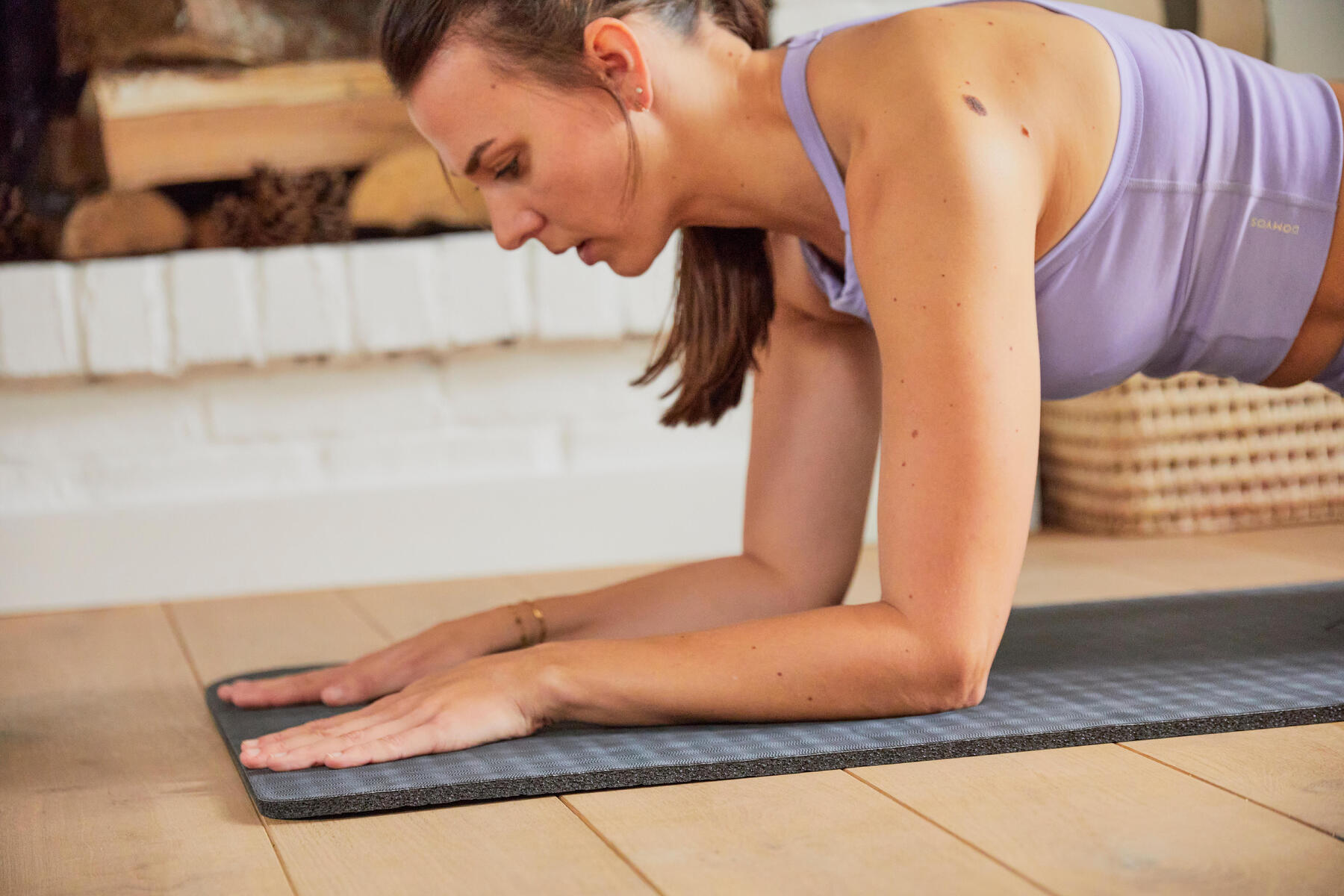 Kobieta wykonująca plank na macie w stroju sportowym