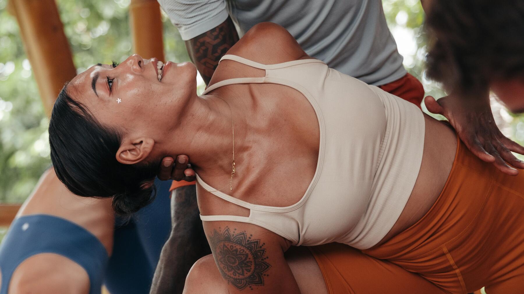 Frau in gelben Sport-BH beim Durchführen von Yoga-Asana.