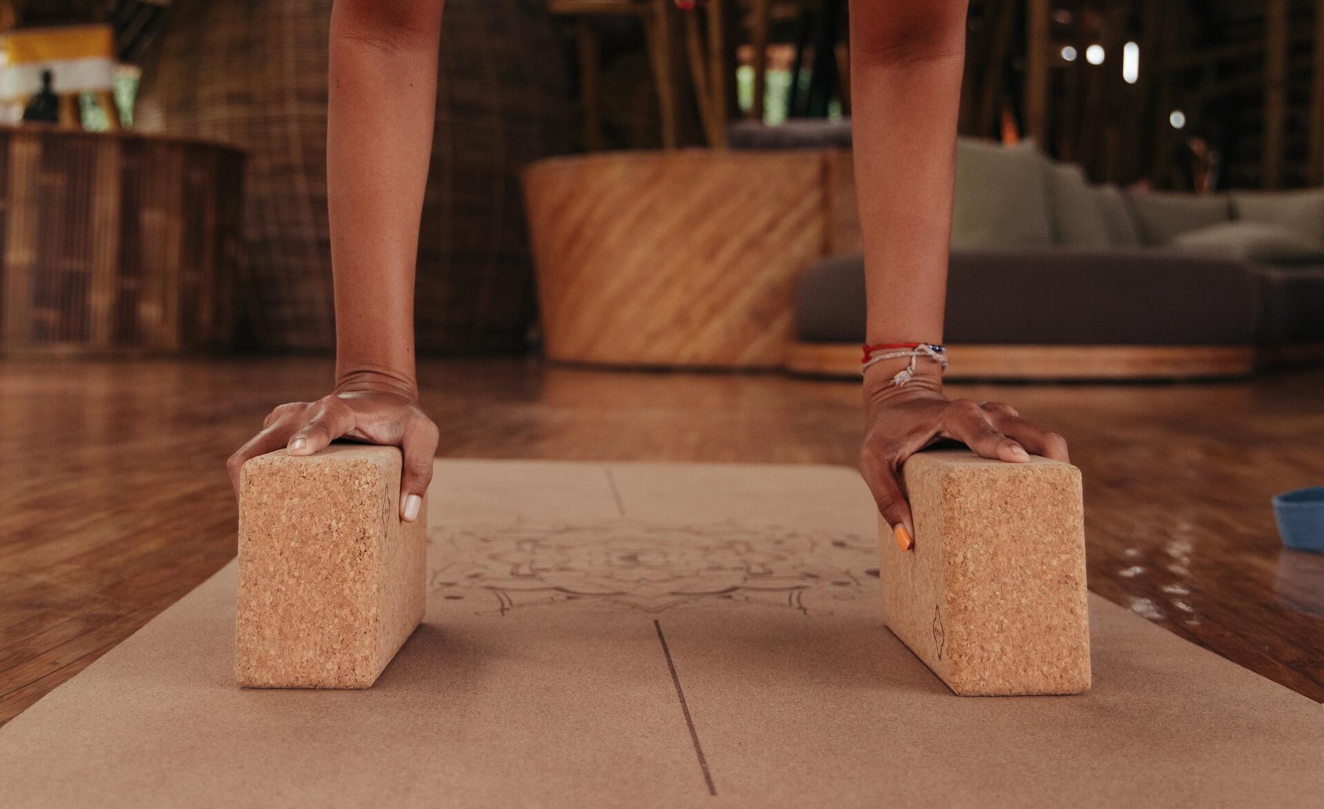 Man leaning on a cork block to maintain a yoga pose