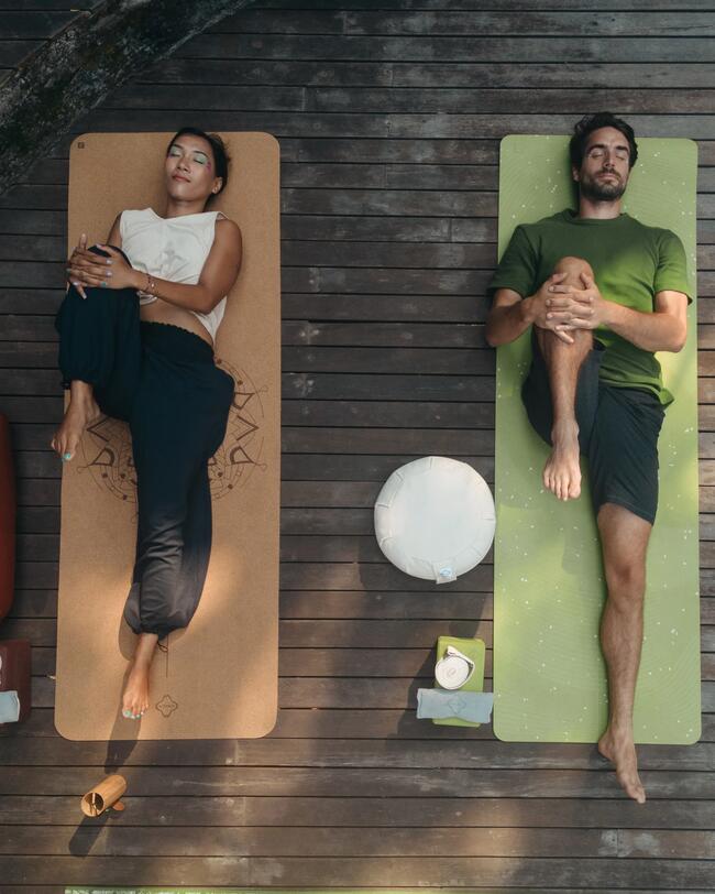 Eine Frau und ein Mann machen Yoga. 