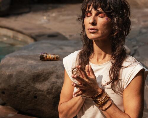 Frau übt Tantra Yoga Achtsamkeit mit geschlossenen Augen