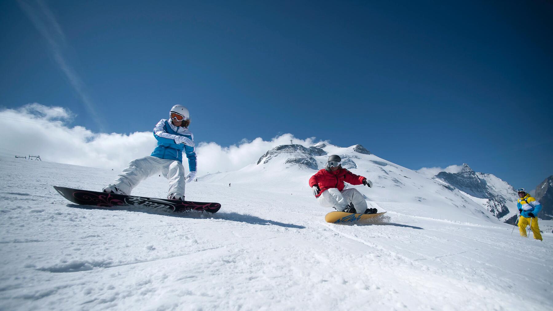 Twee mensen lekker samen aan het snowboarden op de piste