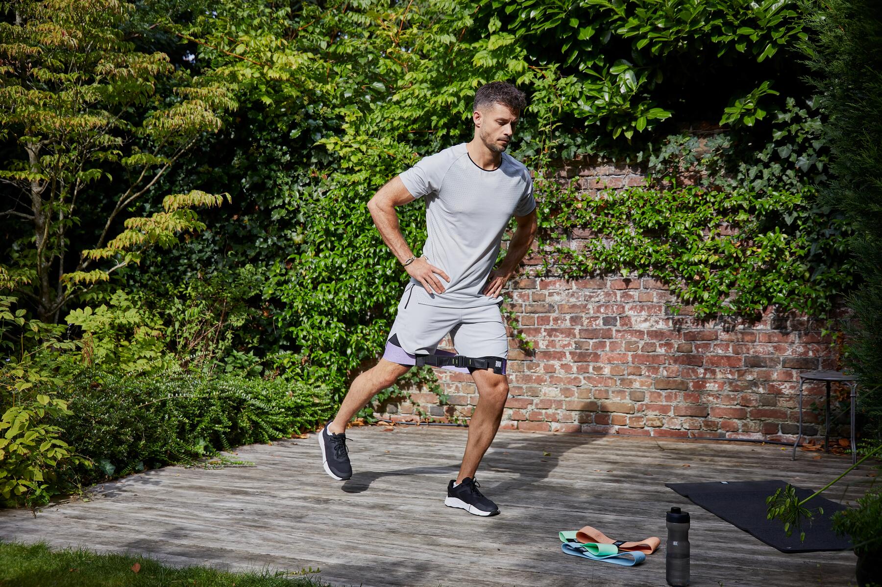 Iemand die een fitnesselastiek gebruikt in zijn tuin