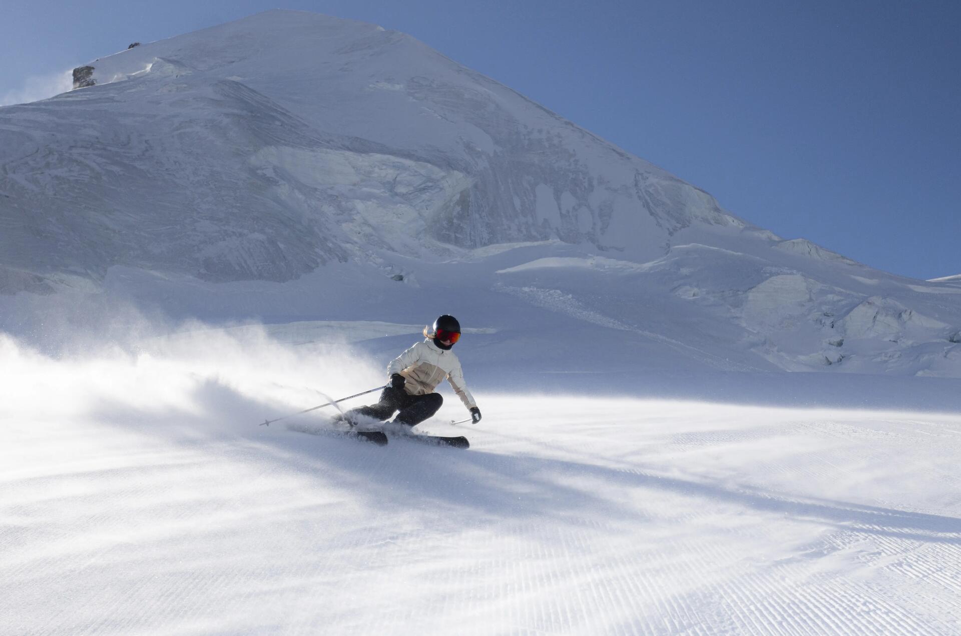 osoba w kasku i goglach narciarskich na stoku narciarskim jadąca na nartach śmigiem 